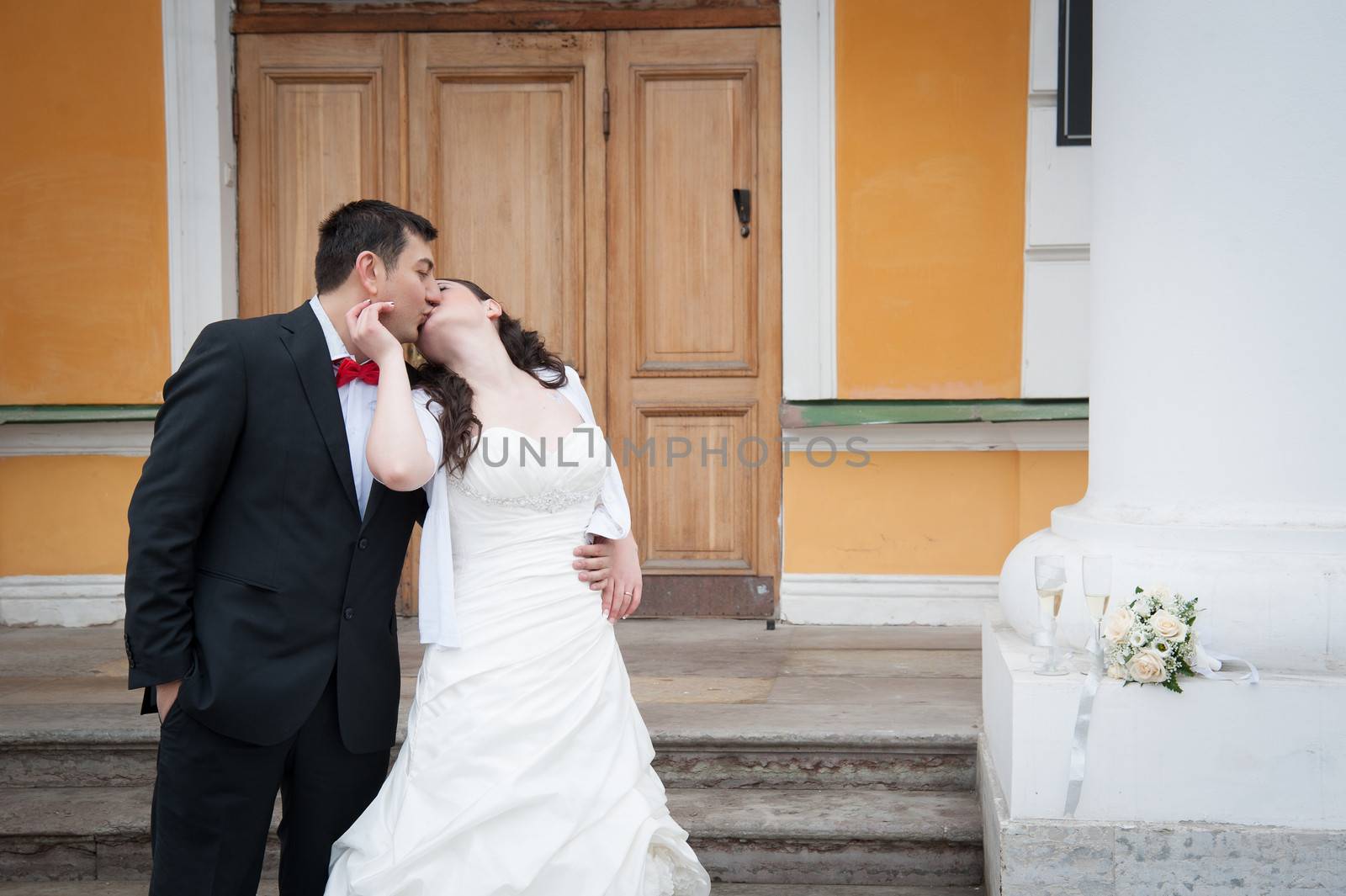 bride and groom standing in front of the palace