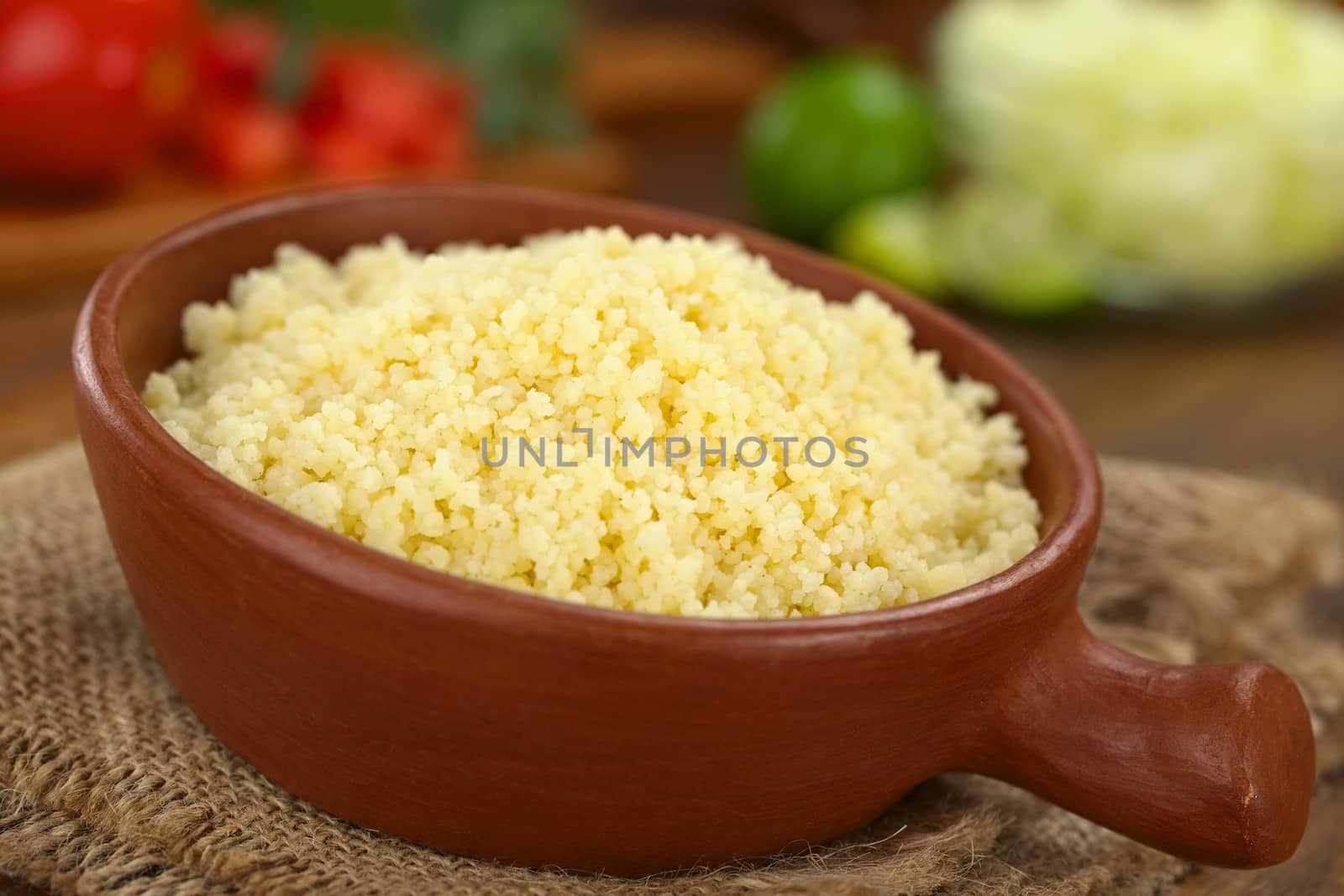 Prepared couscous in rustic bowl (Selective Focus, Focus one third into the couscous)