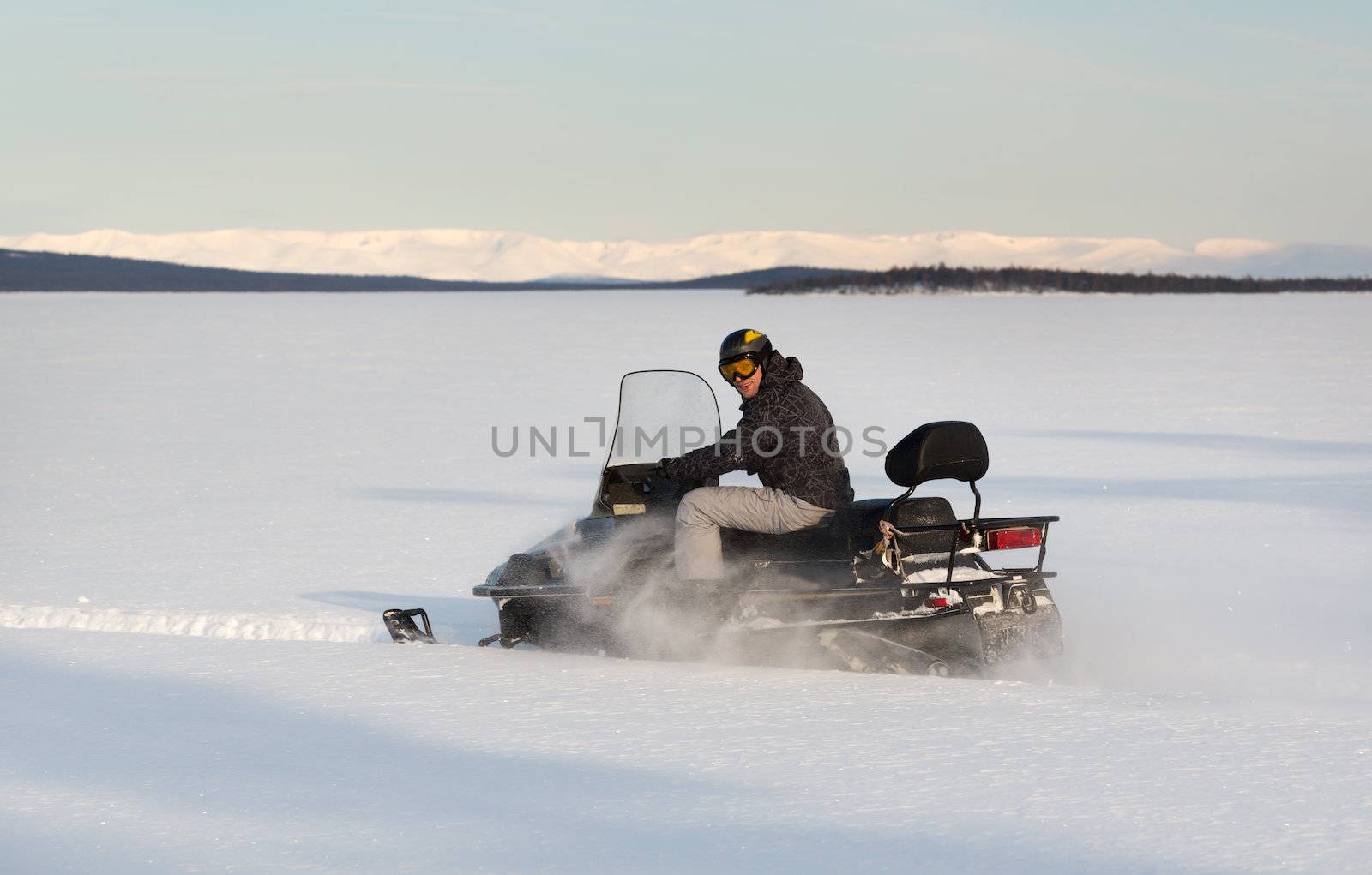 Snowmobile action sport in north Russia. a lot of fun driving those fast snow mobiles over frozen lakes and the snow landscape