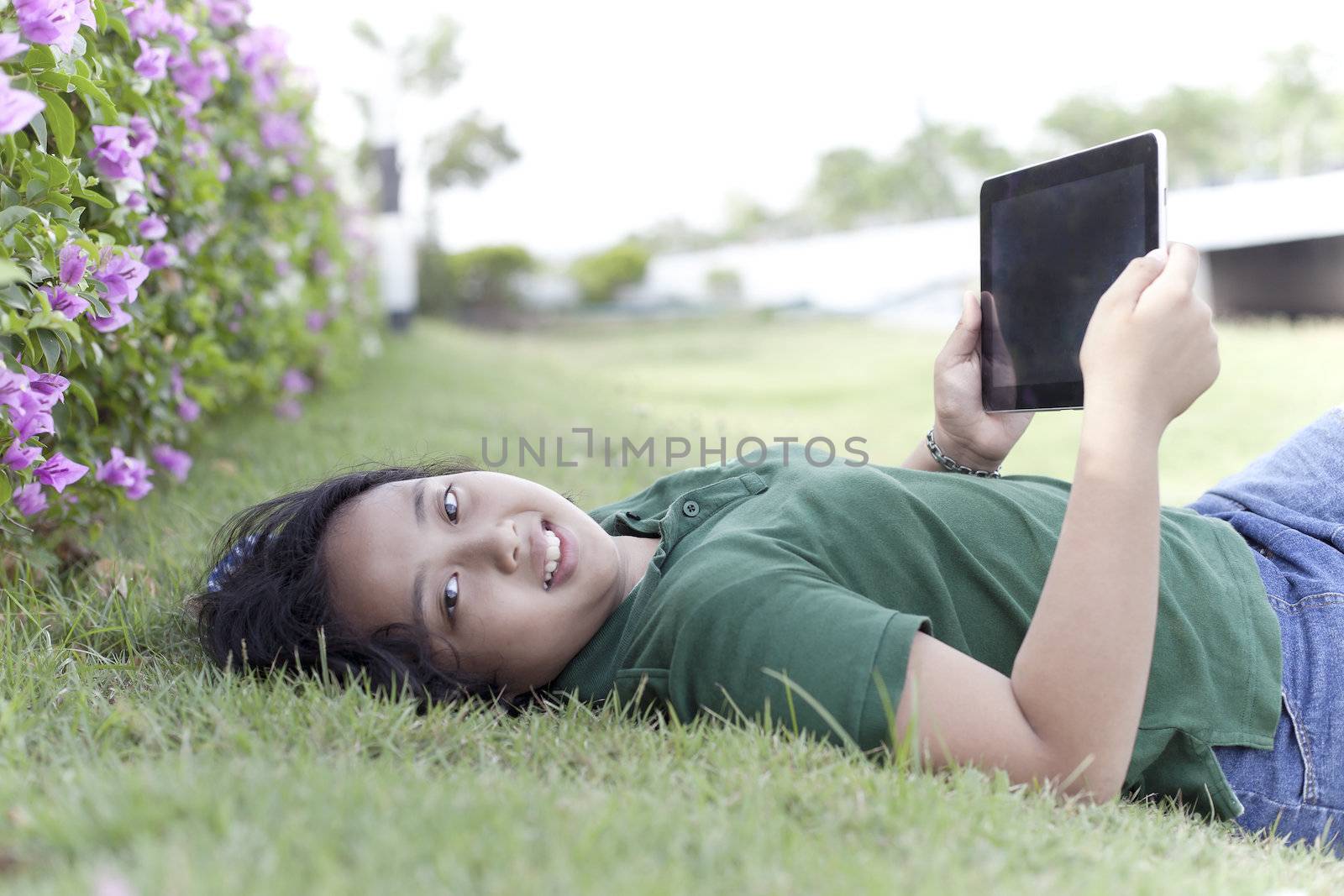 girl and tablet computer on green grass  by khunaspix