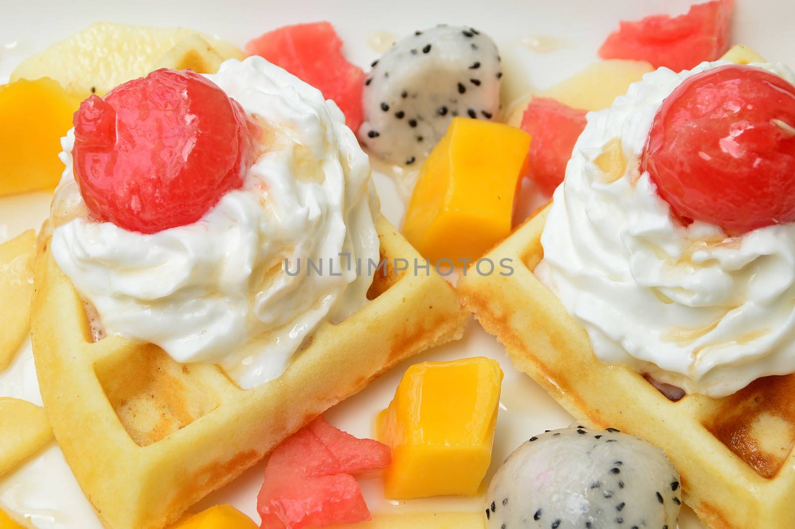 waffles with fresh fruits and cream on white plate