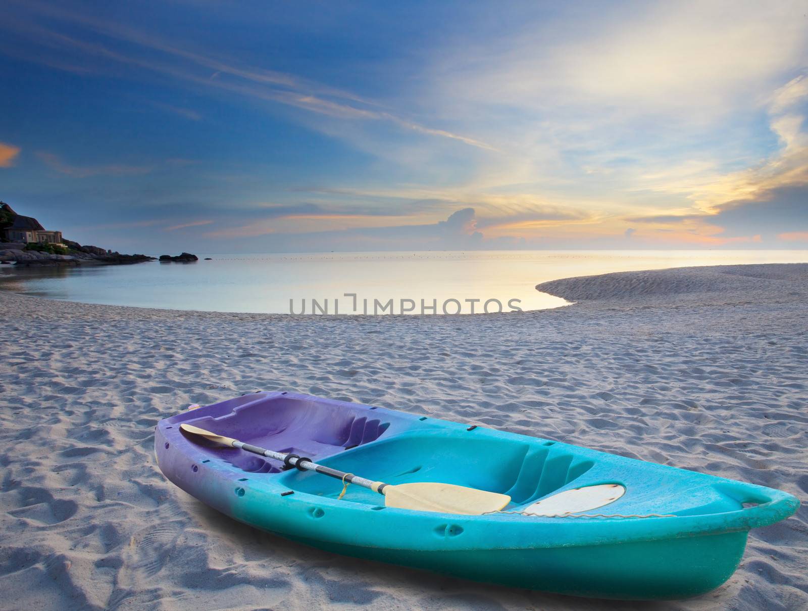 green sea kayak on sand beach by khunaspix