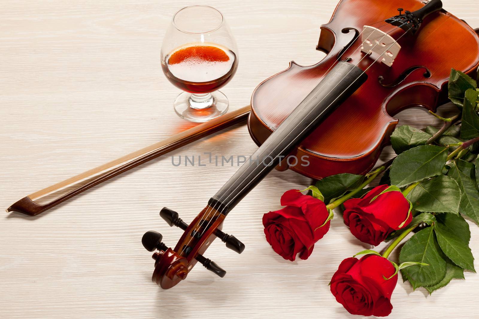 Red roses and a violin on the table