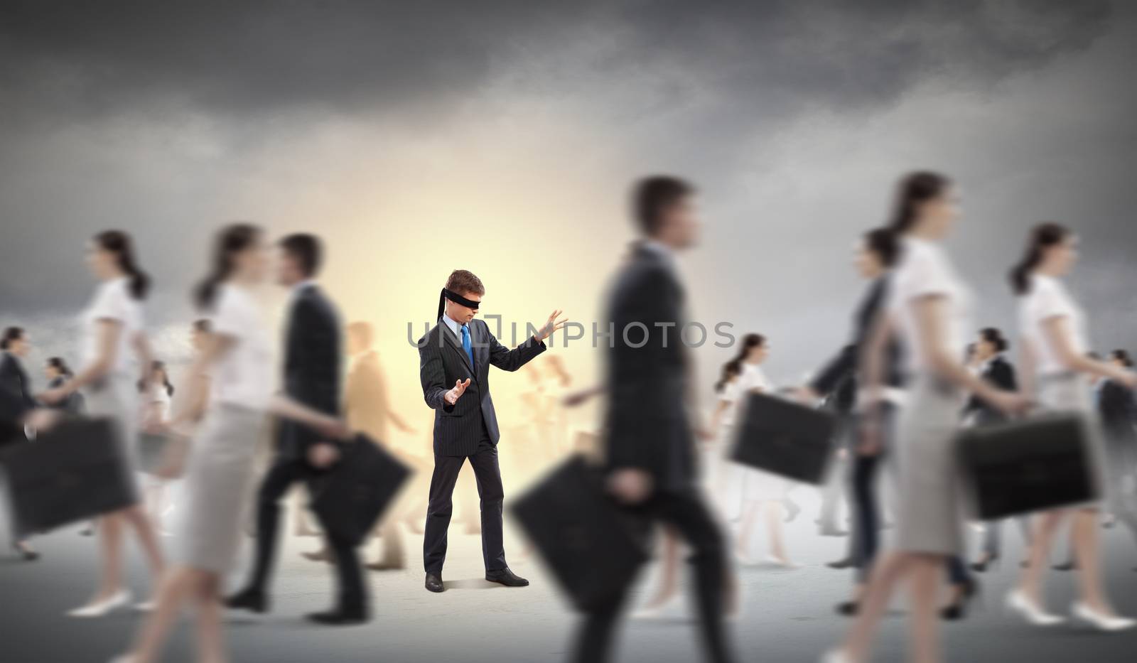 Image of businessman in blindfold walking among group of people