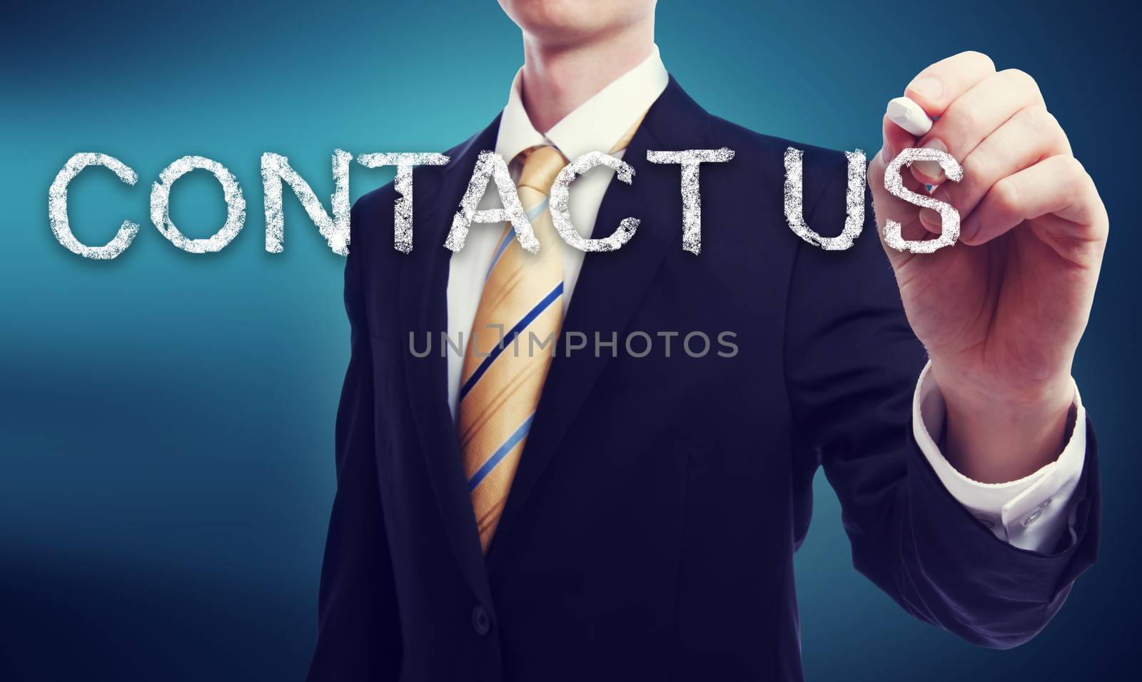 Business Man Writing Contact Us in Chalk with Glowing Blue Background