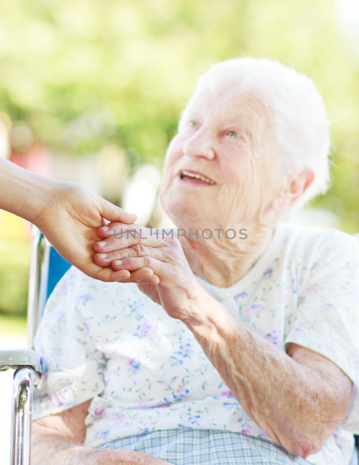 Senior woman holding hands with caretaker by melpomene