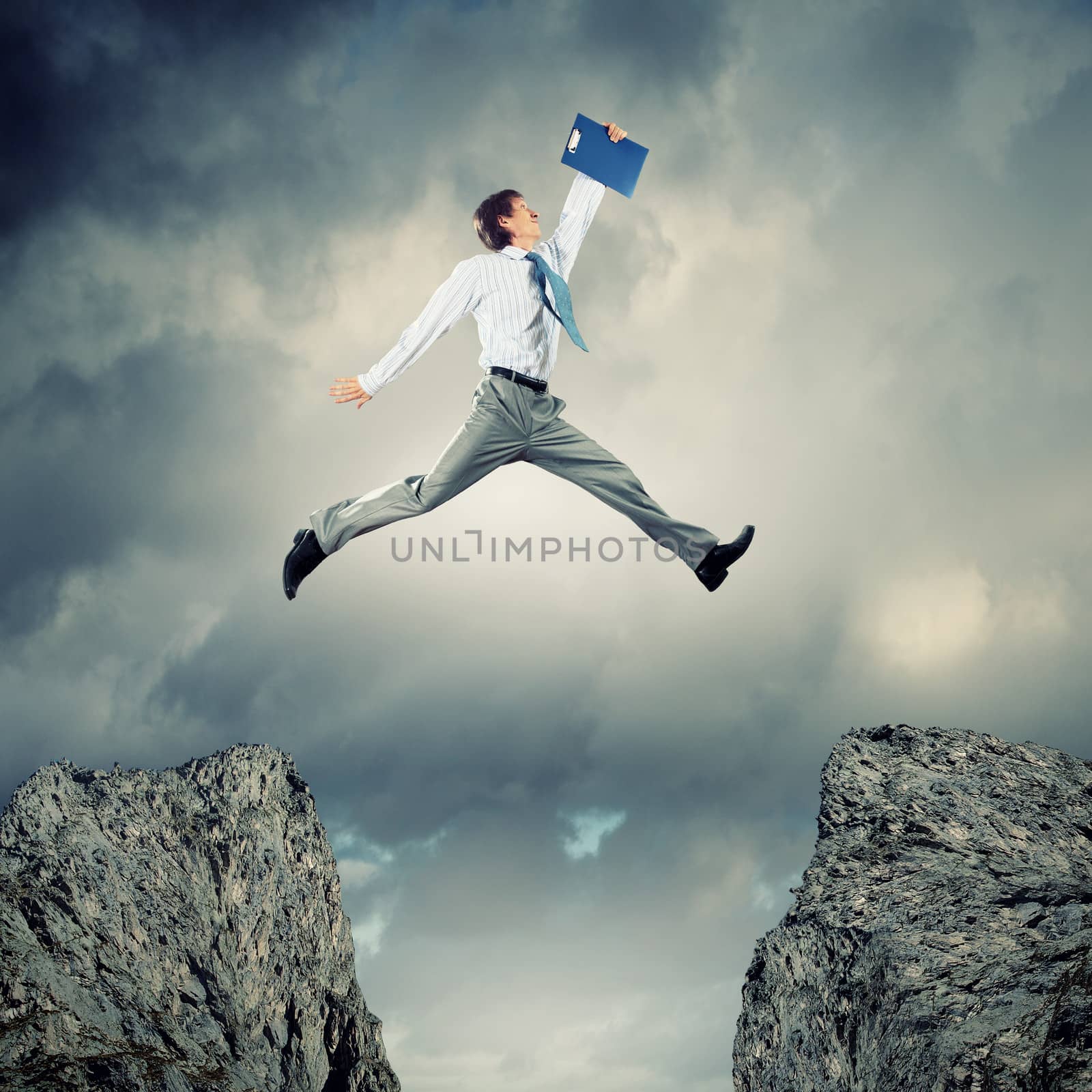 Image of young businessman jumping over gap