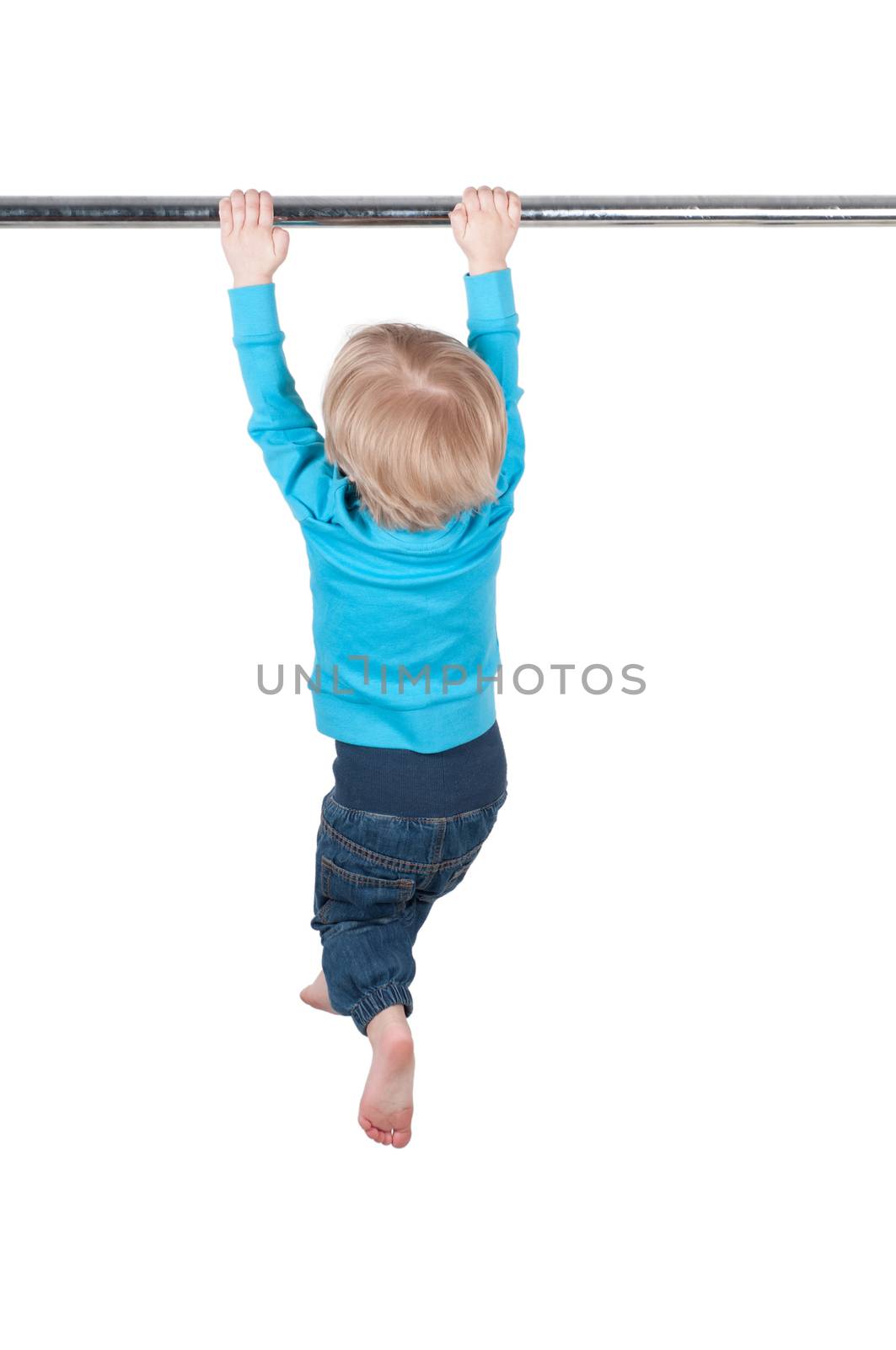 Little boy in blue hanging on the bar