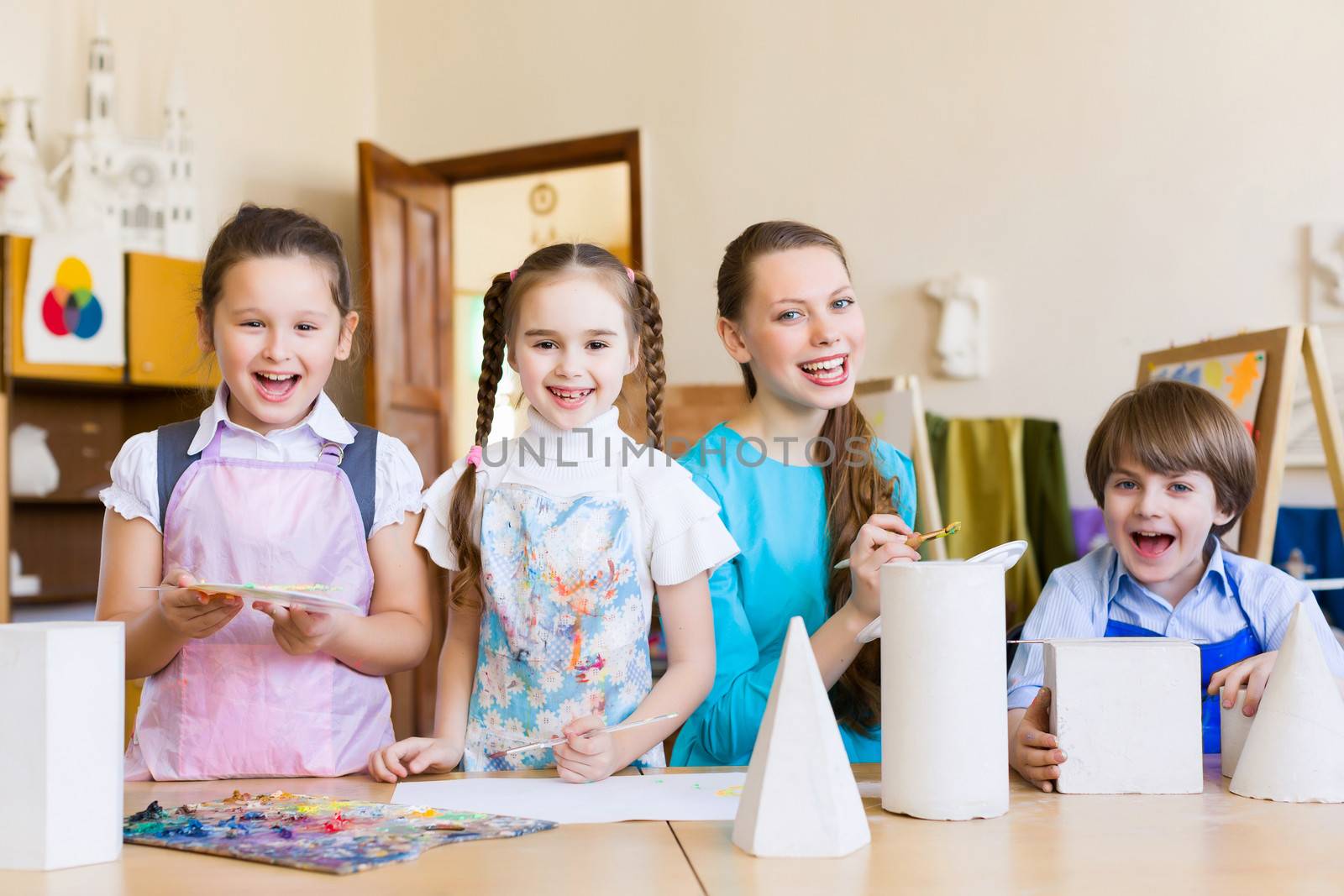 Little children painting and playing at kindergarten