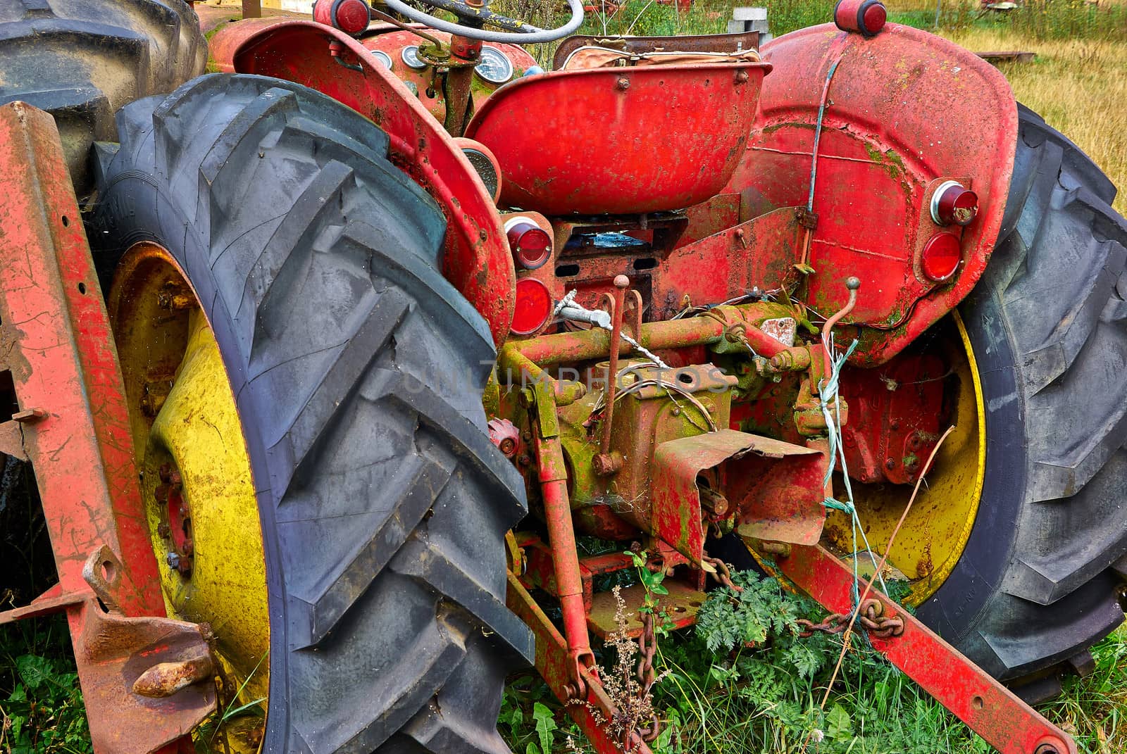 Close details of an old abandoned rusty tractor in a farm
