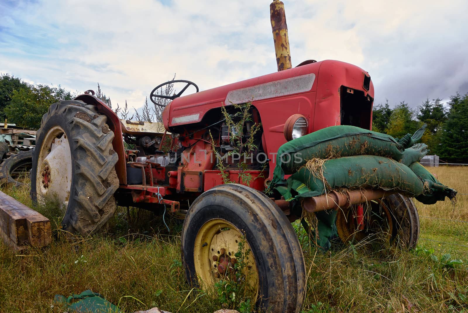 Close details of an old abandoned rusty tractor in a farm