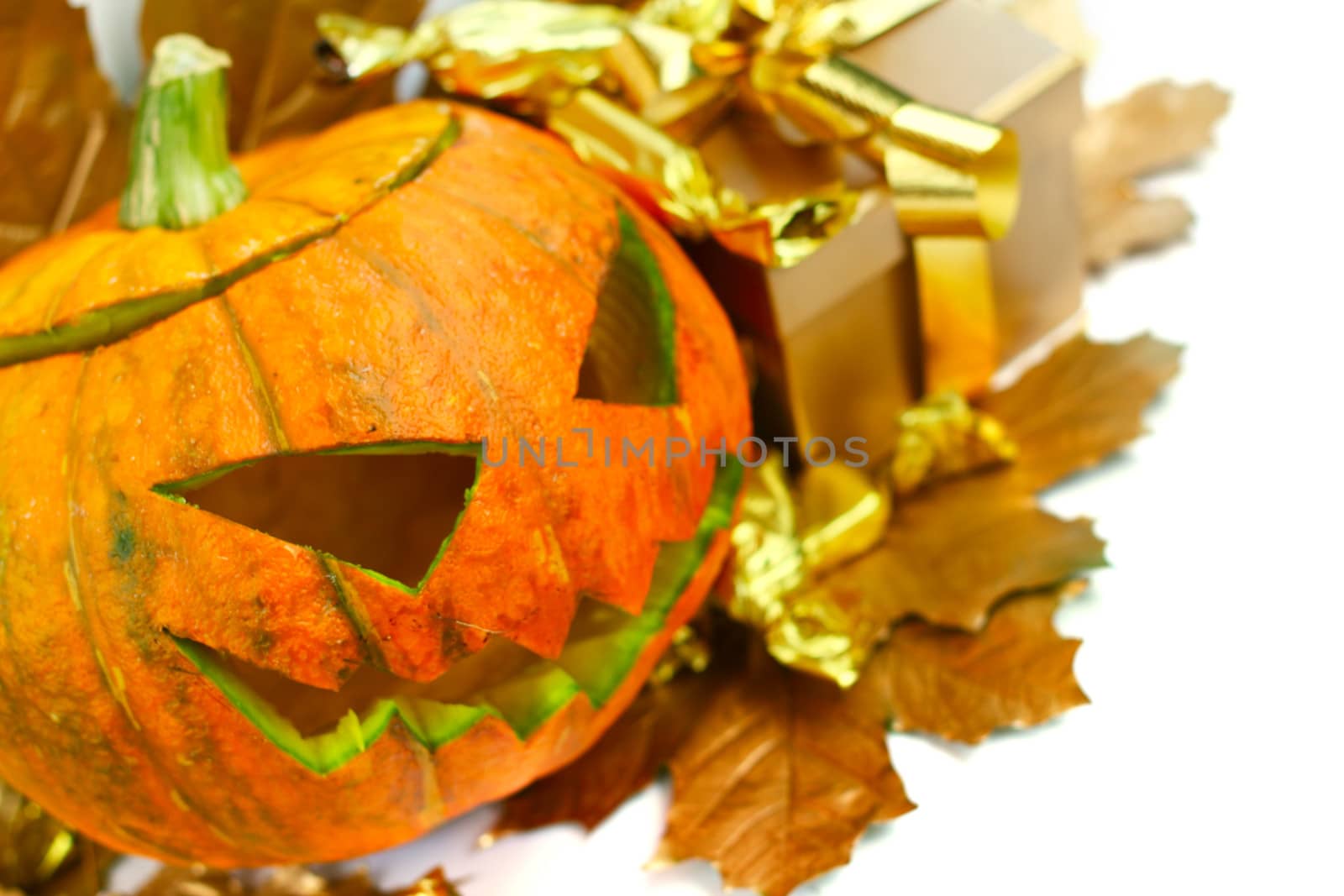 Halloween pumpkin with autumn leafs and gift isolated on white