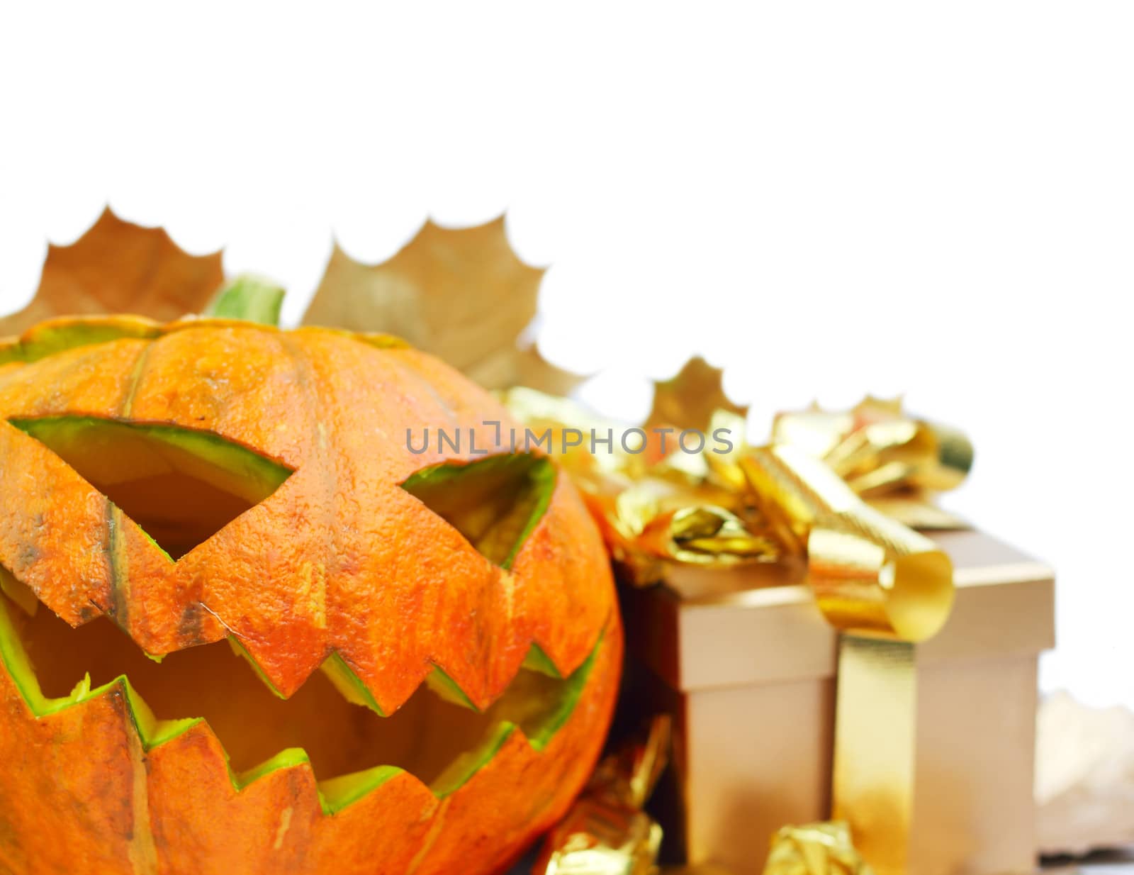 Halloween pumpkin with autumn leafs and gift isolated on white