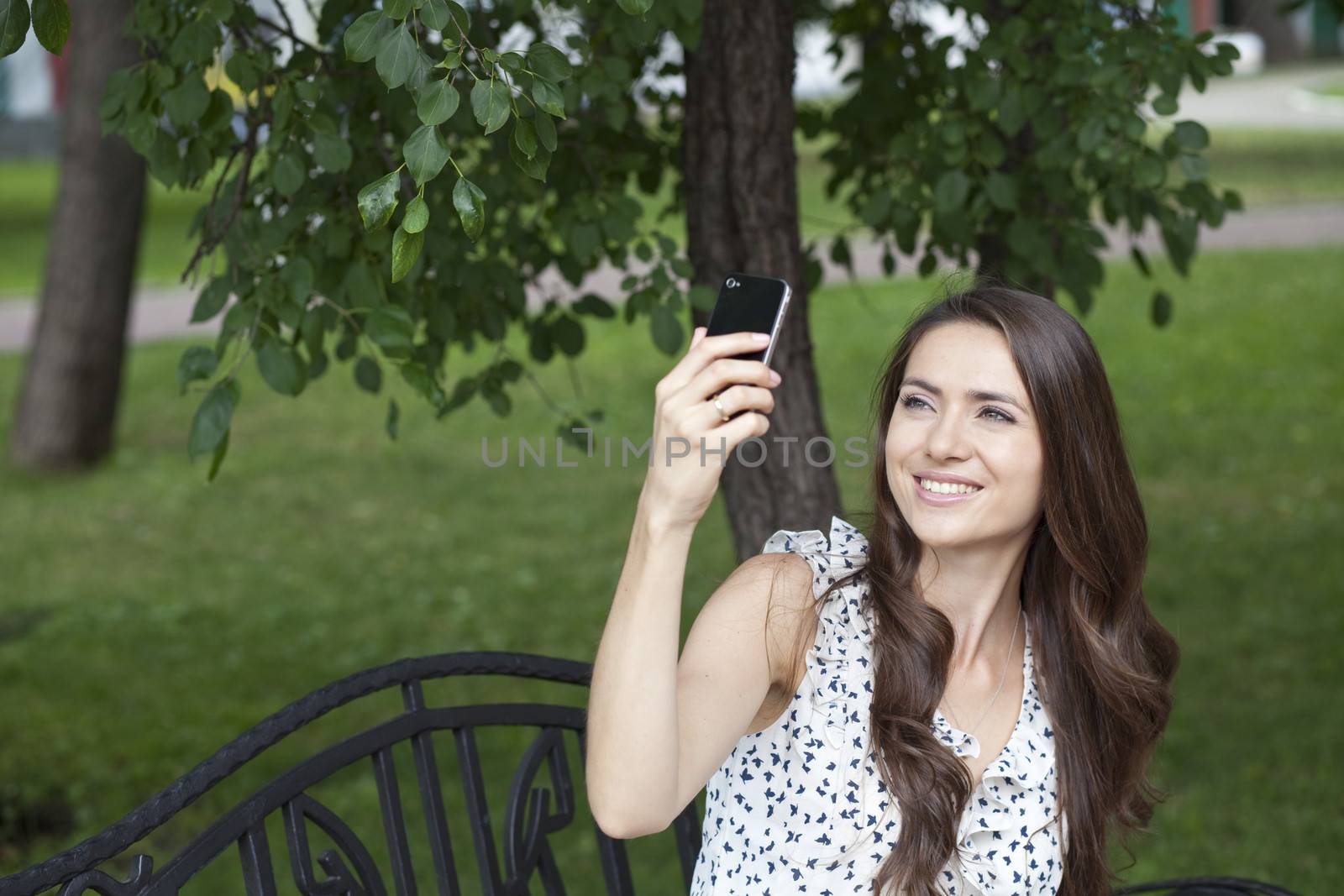 Happy young woman taking pictures on your phone by andersonrise