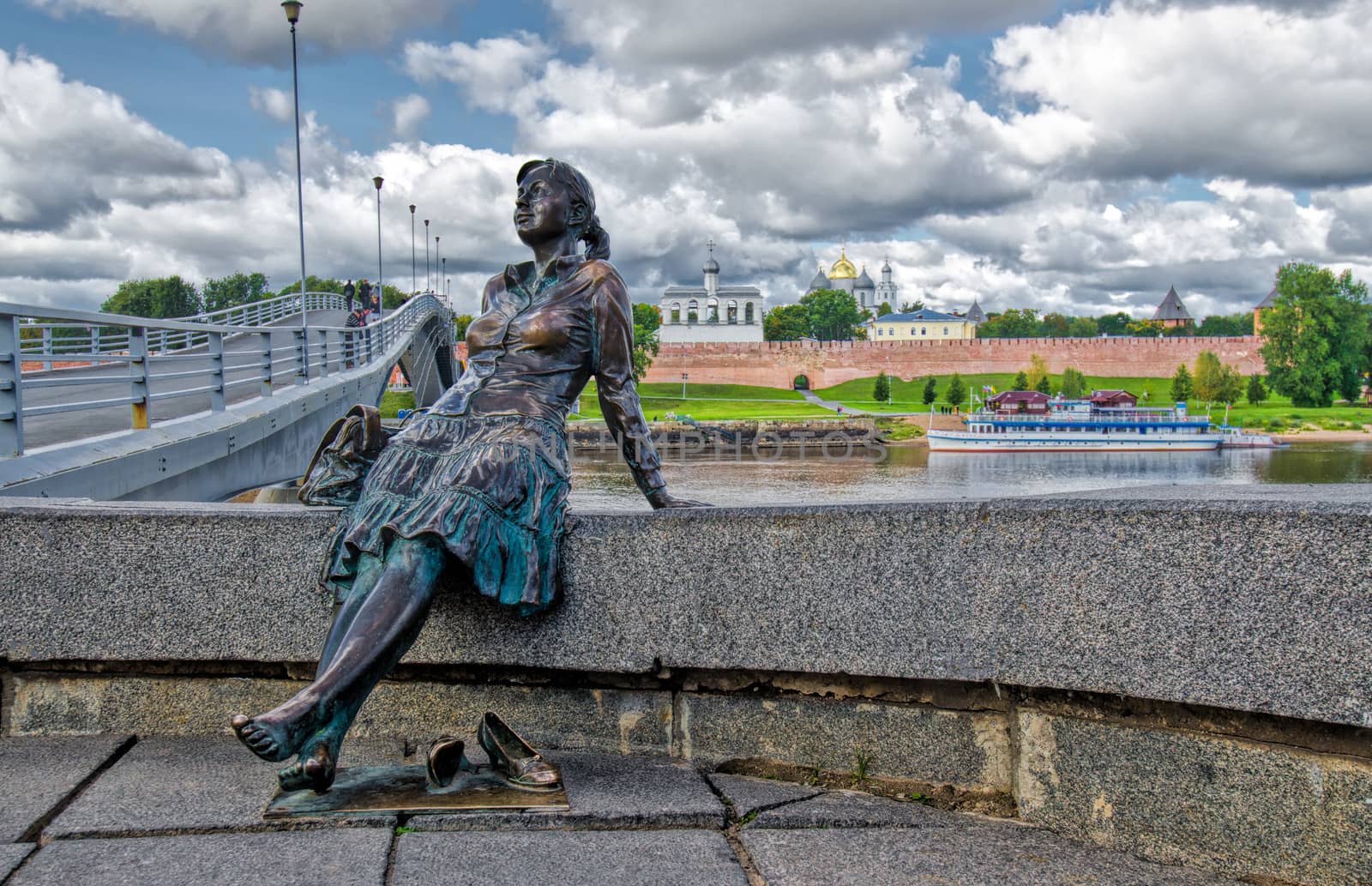 Statue of a lady taking a rest on the river bank wall in Novgorod, Russia