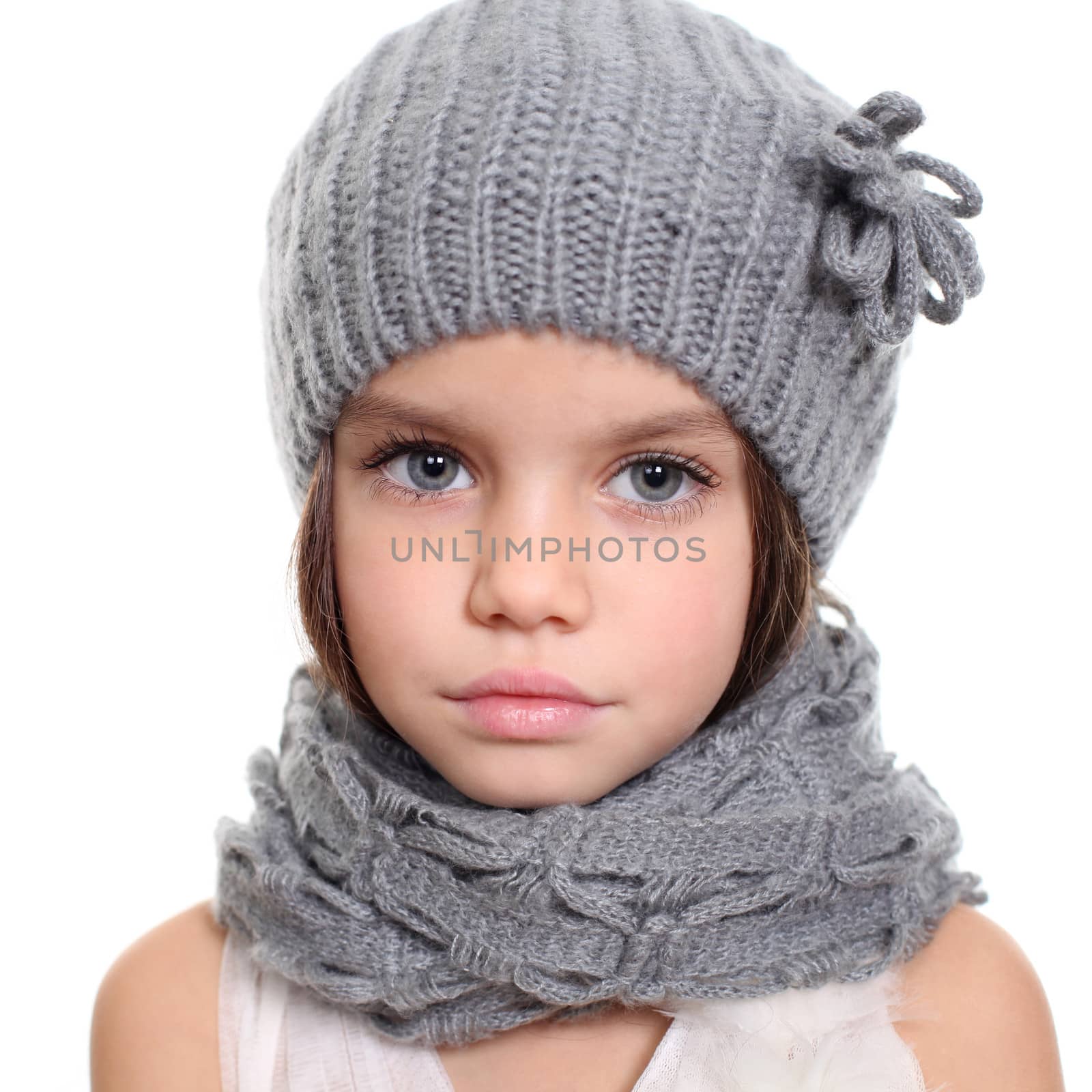 little girl in a knitted hat and gray scarf