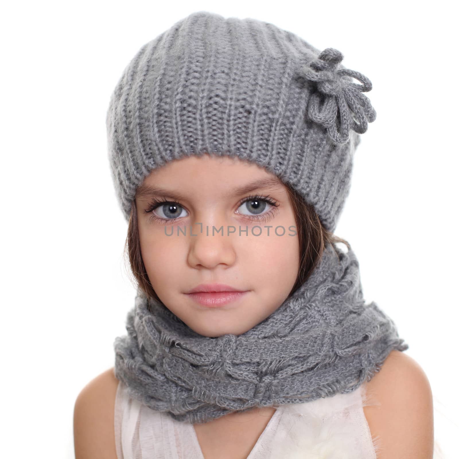 little girl in a knitted hat and gray scarf