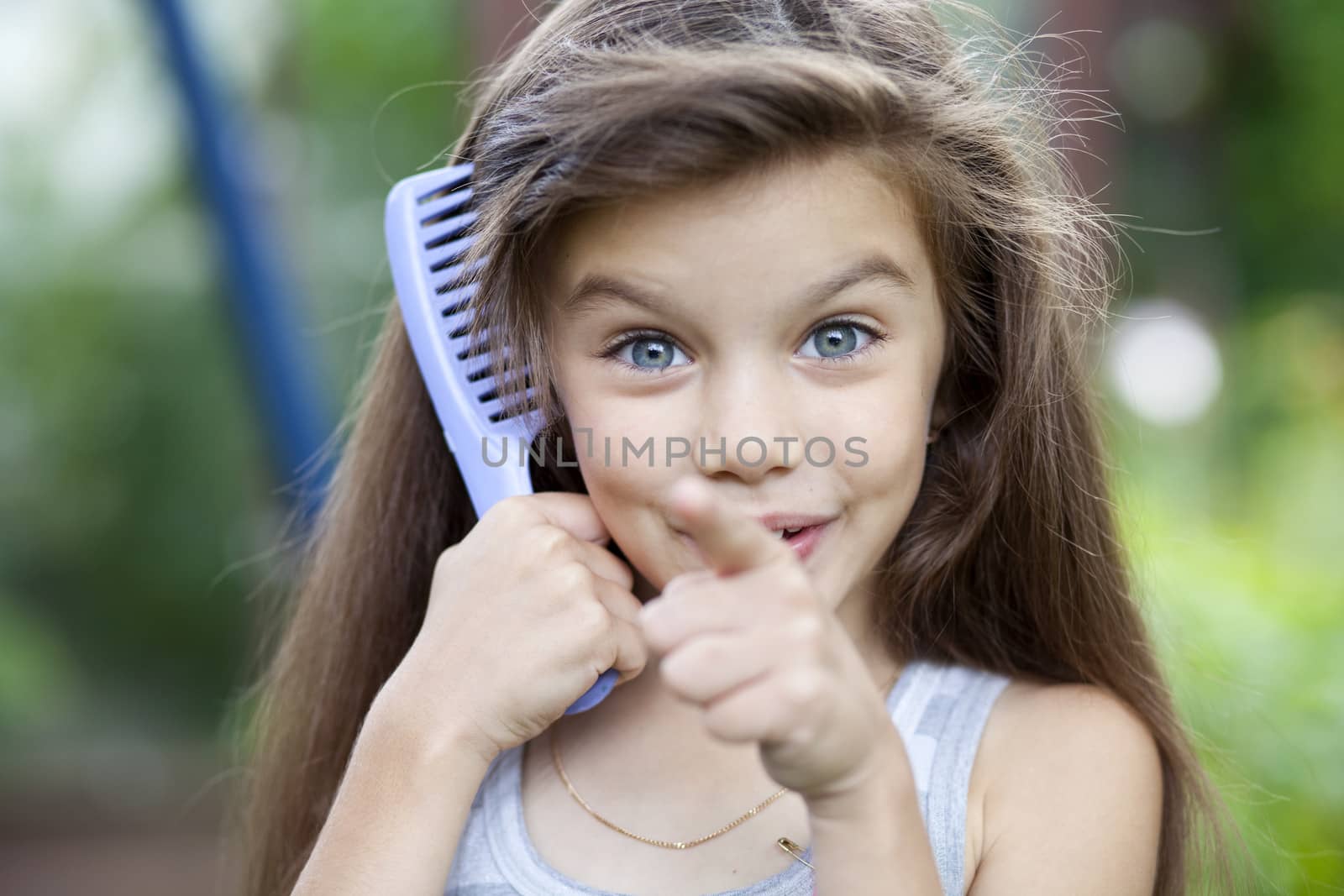 Little girl holding a comb in his hand by andersonrise