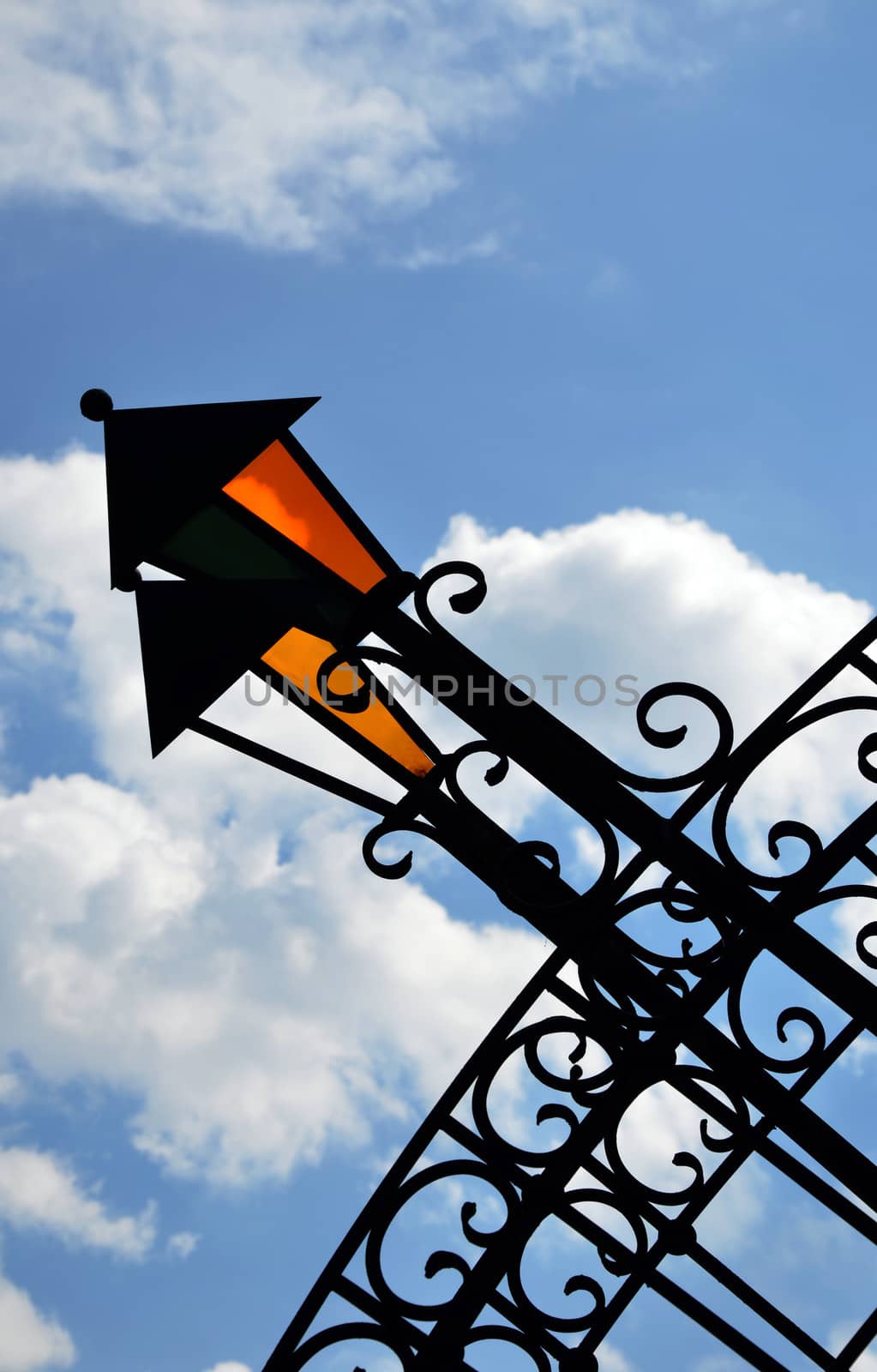 The fragment of decorative wrought bridge with lanterns against the sky and clouds