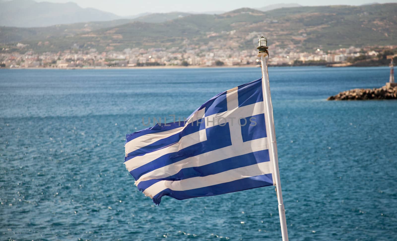 Wavy Greece flag on blue sea background 