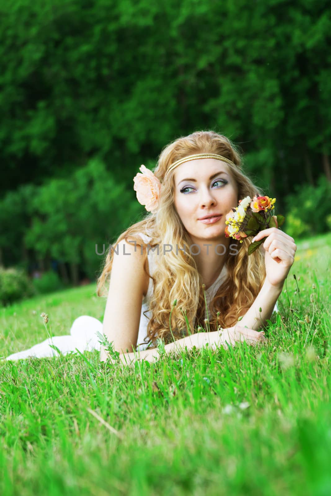 Woman with roses lying among green grass by Angel_a