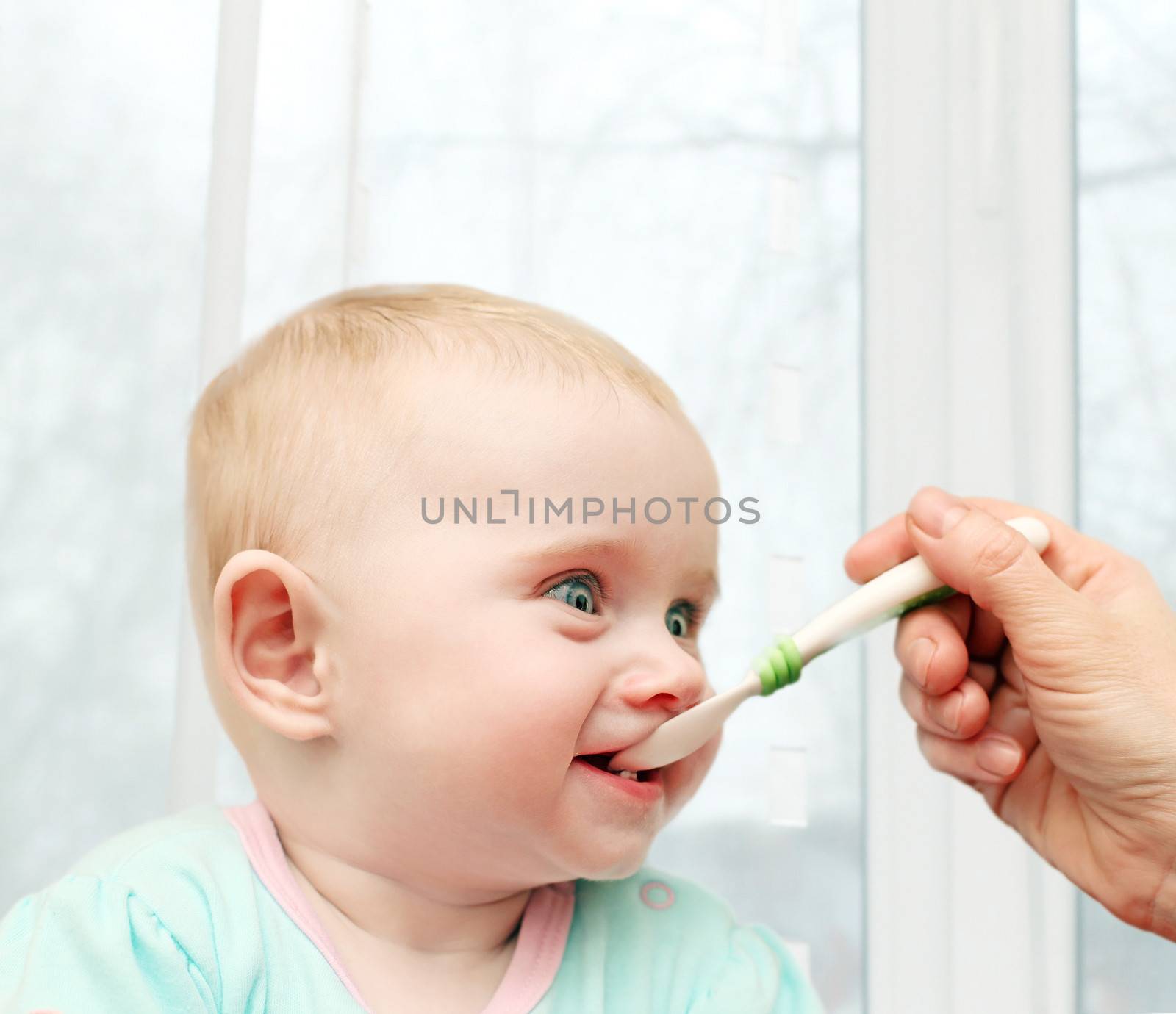 Parent feeding Hungry Baby in home interior