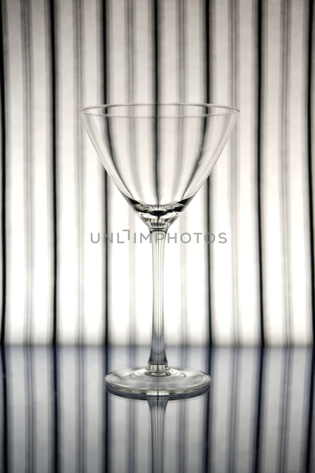 Cocktail glass in front of striped background
