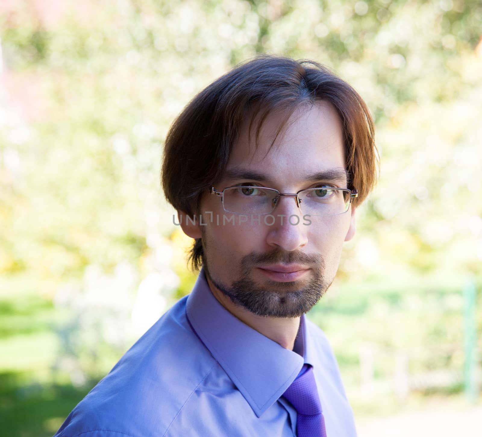 Successful, a serious businessman wearing glasses, shirt and tie on a sunny day.