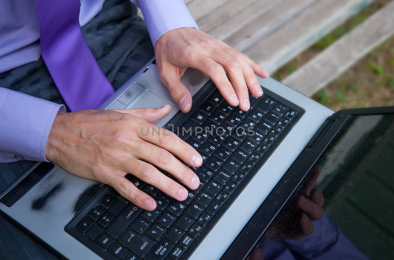 male hands typing on a laptop keyboard