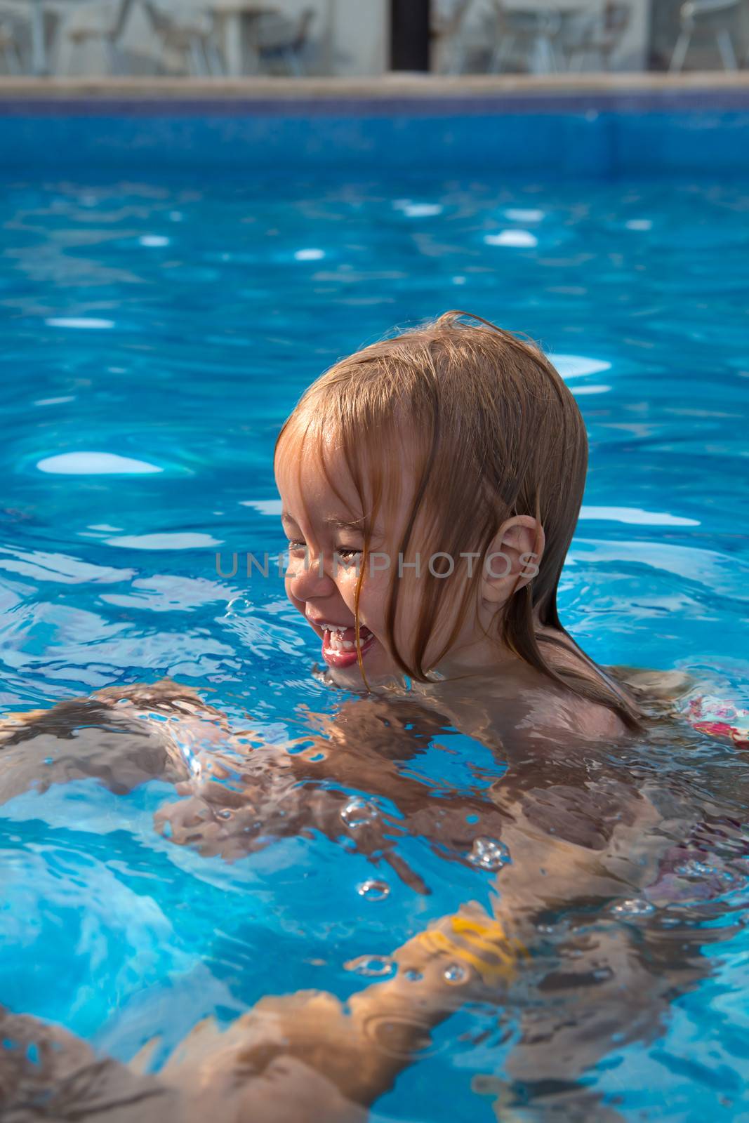 child learning how to swing in pool