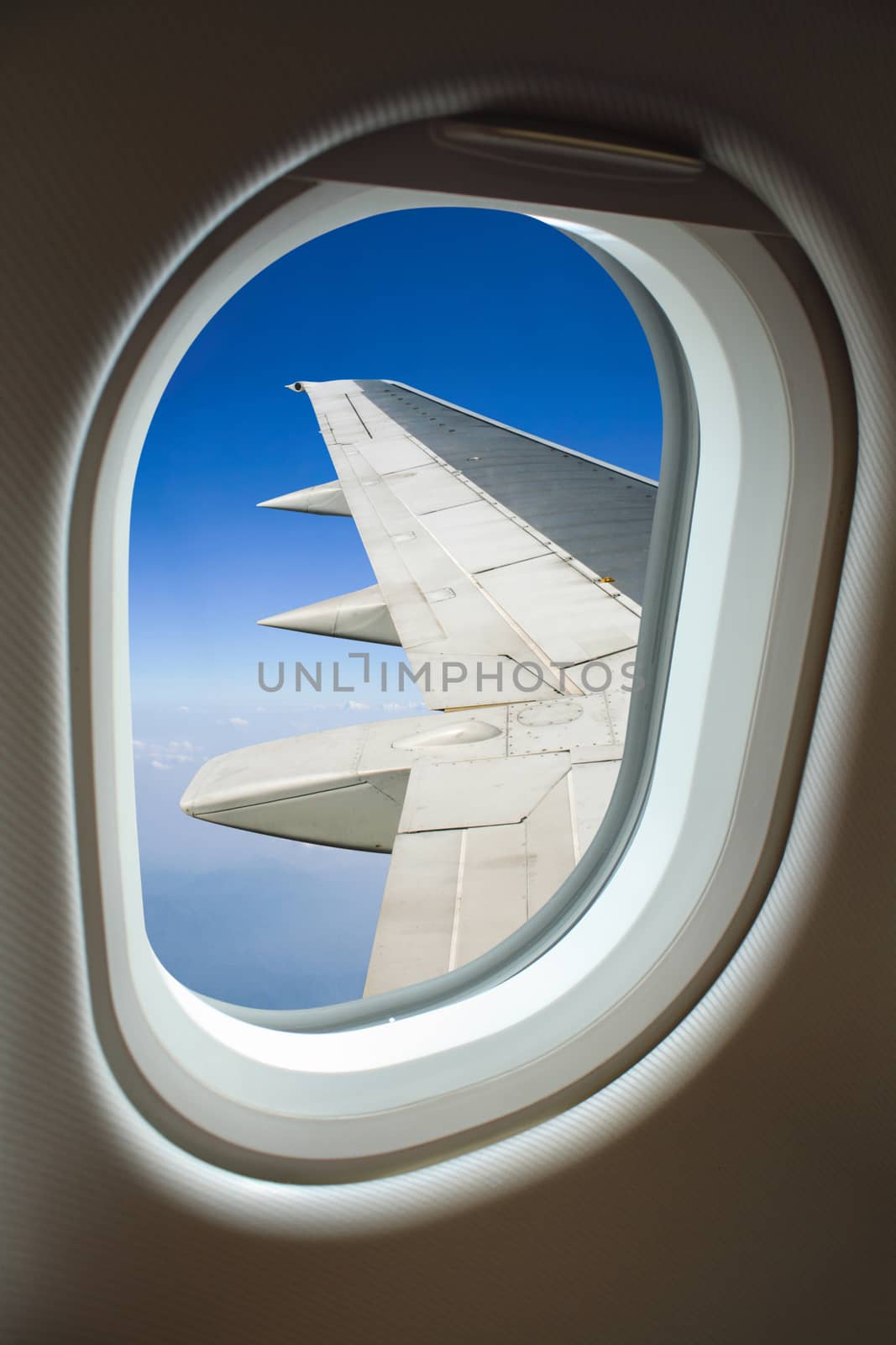 View above clouds from window with airplane