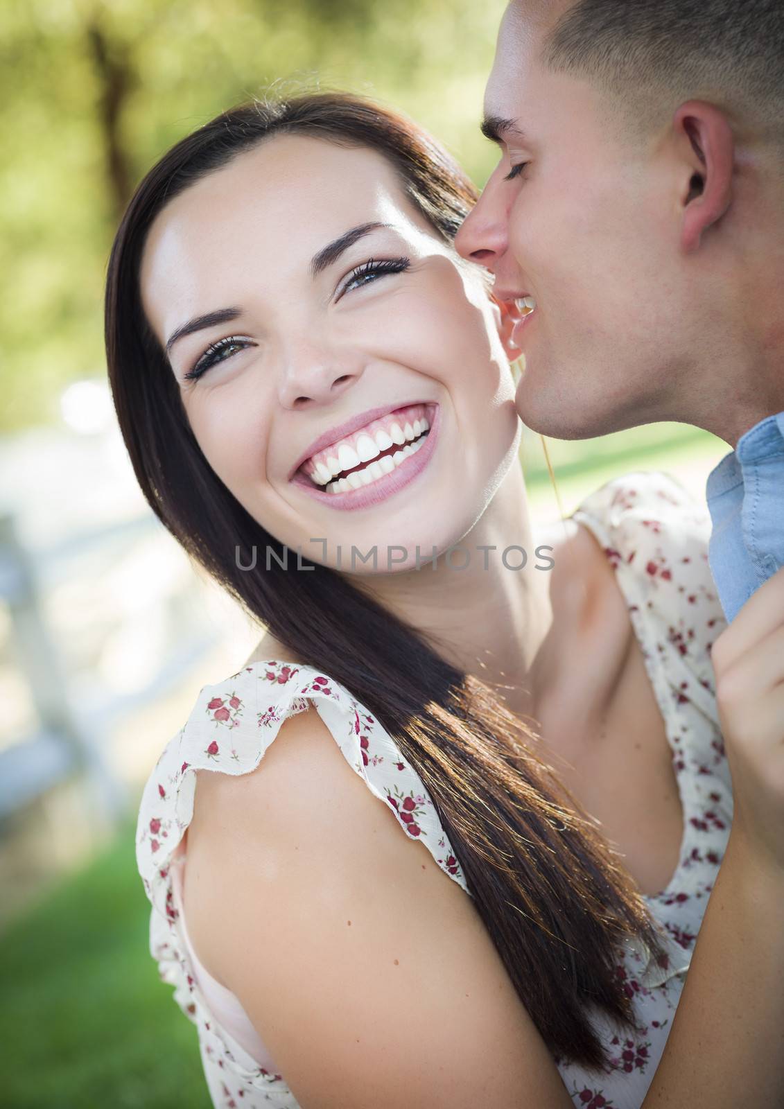Happy Mixed Race Romantic Couple Whispering in the Park.