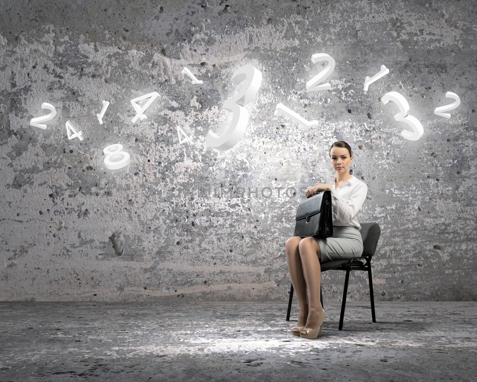 Image of businesswoman sitting on chair with suitcase in hands