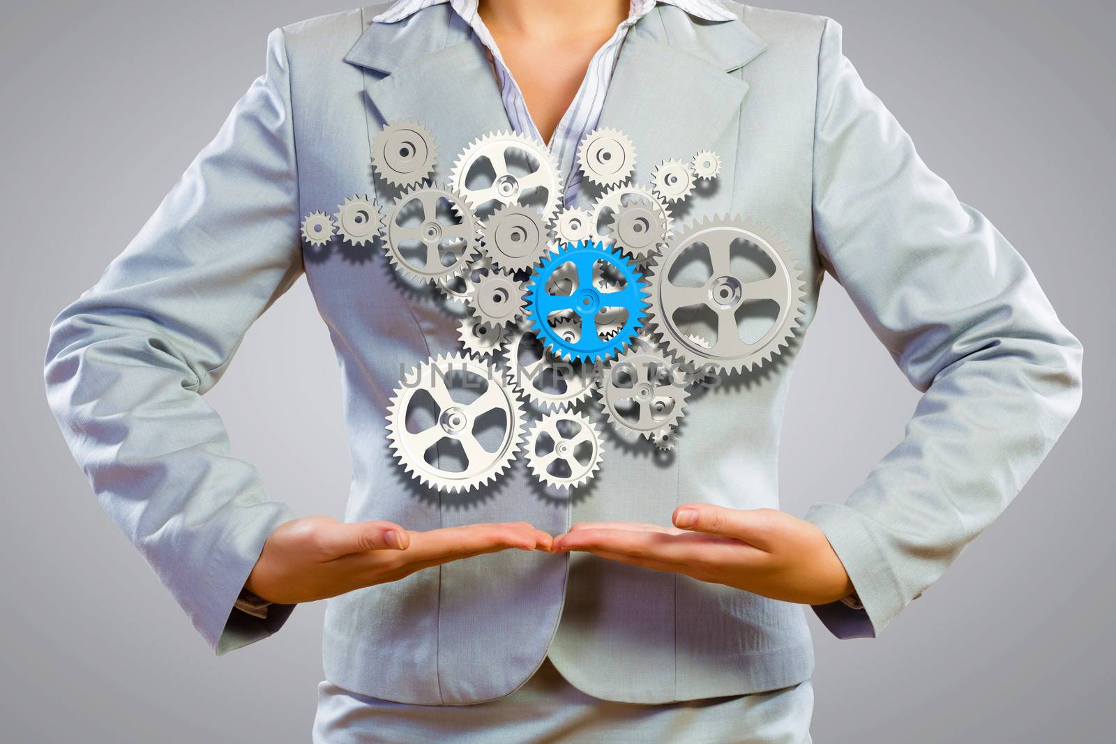 Close up image of businesswoman holding gears in hands