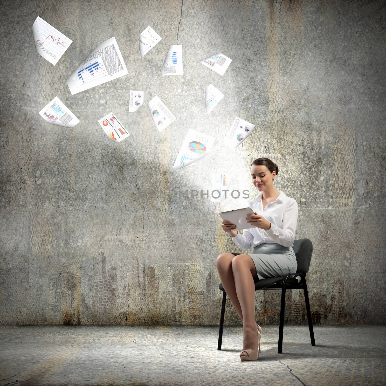 Image of businesswoman sitting on chair with tablet pc in hands