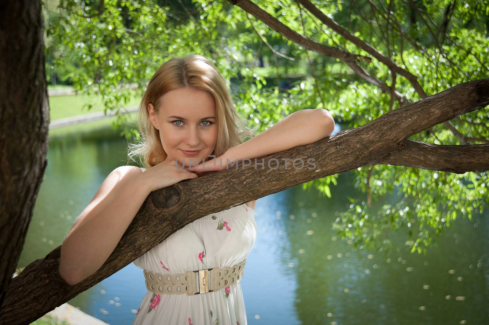 beautiful young woman on a background of foliage and water