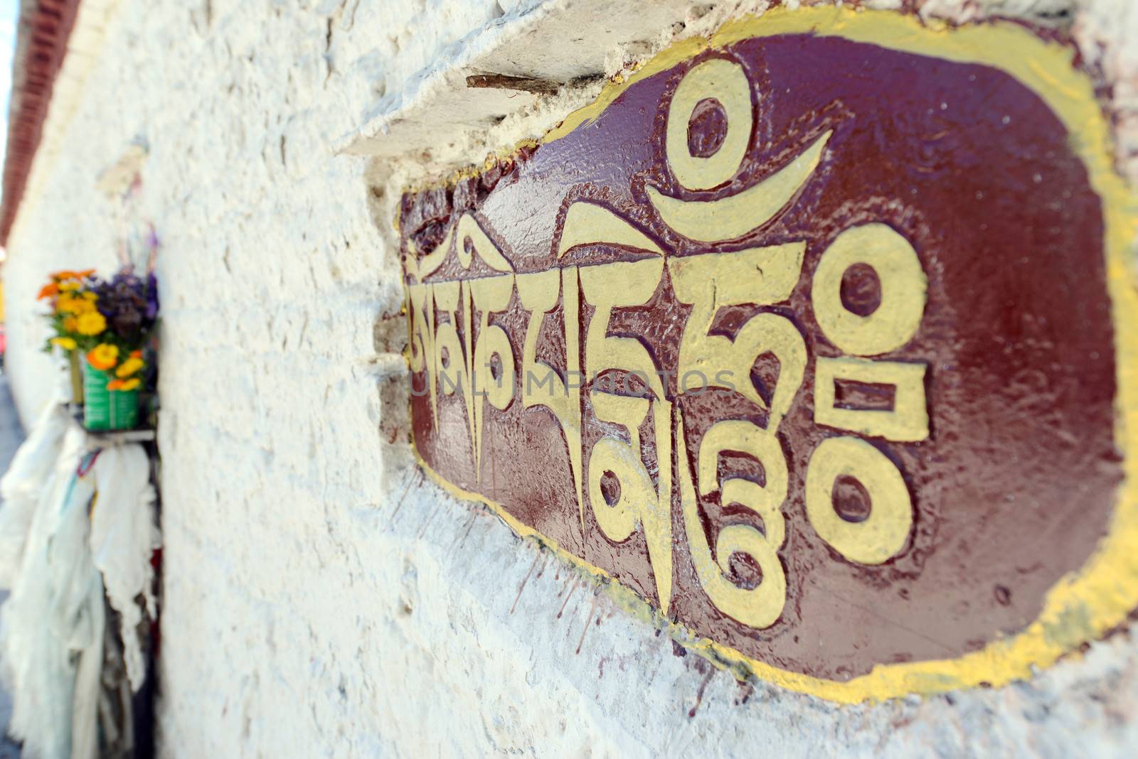 Golden buddhist prayer words on the wall in Tibet