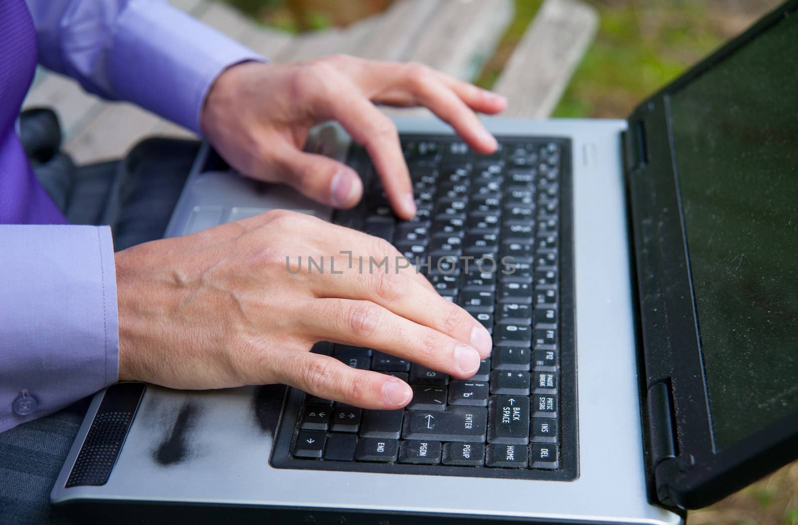 male hands typing on a laptop keyboard