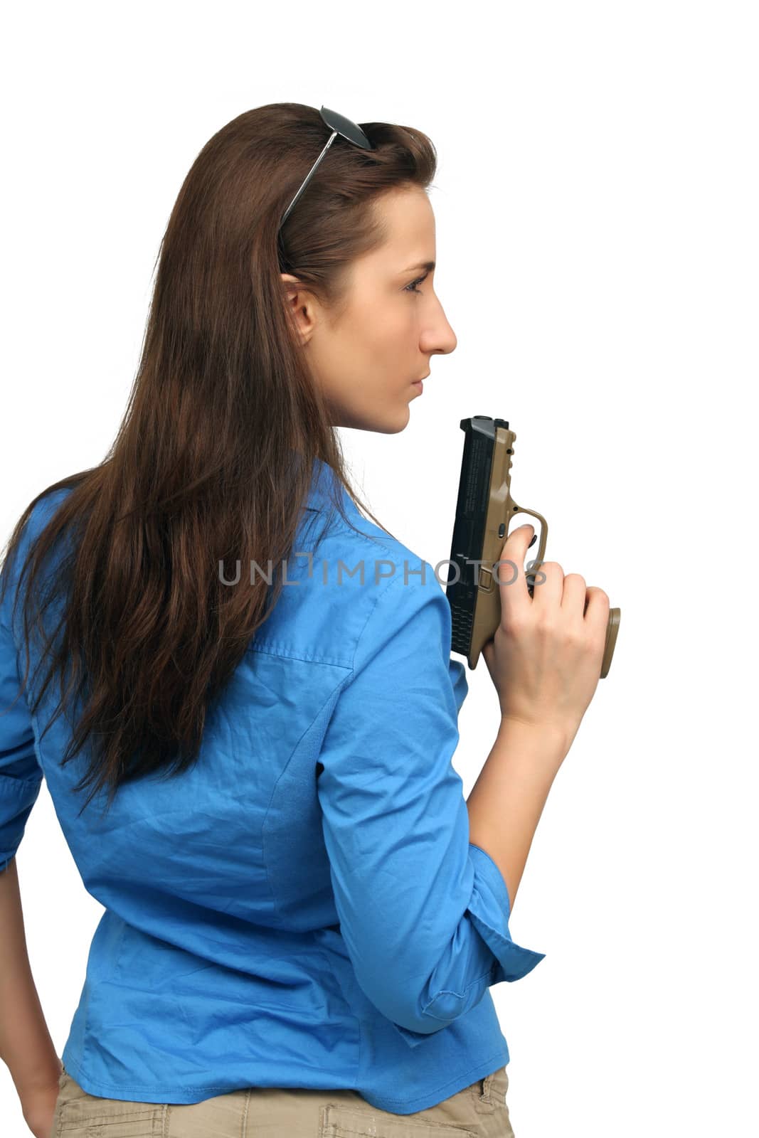 A lovely young brunette holds a modern handgun.  Isolated on a white background with generous copyspace.