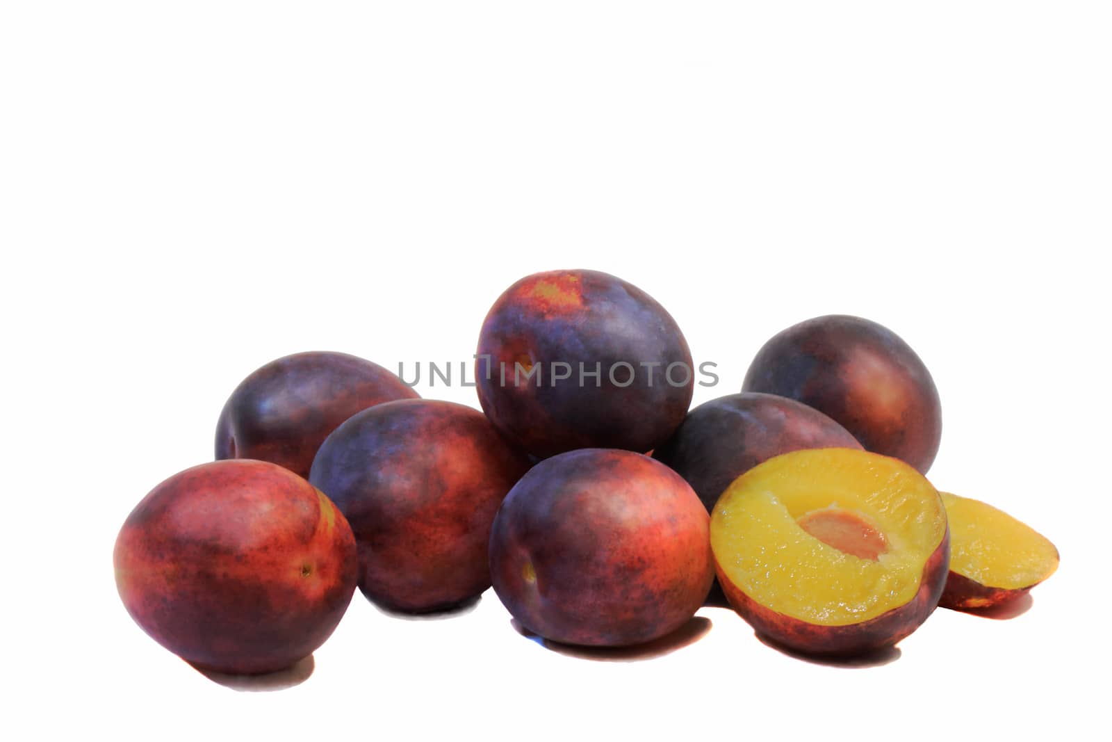 Large ripe plum and one exploded drain on white background