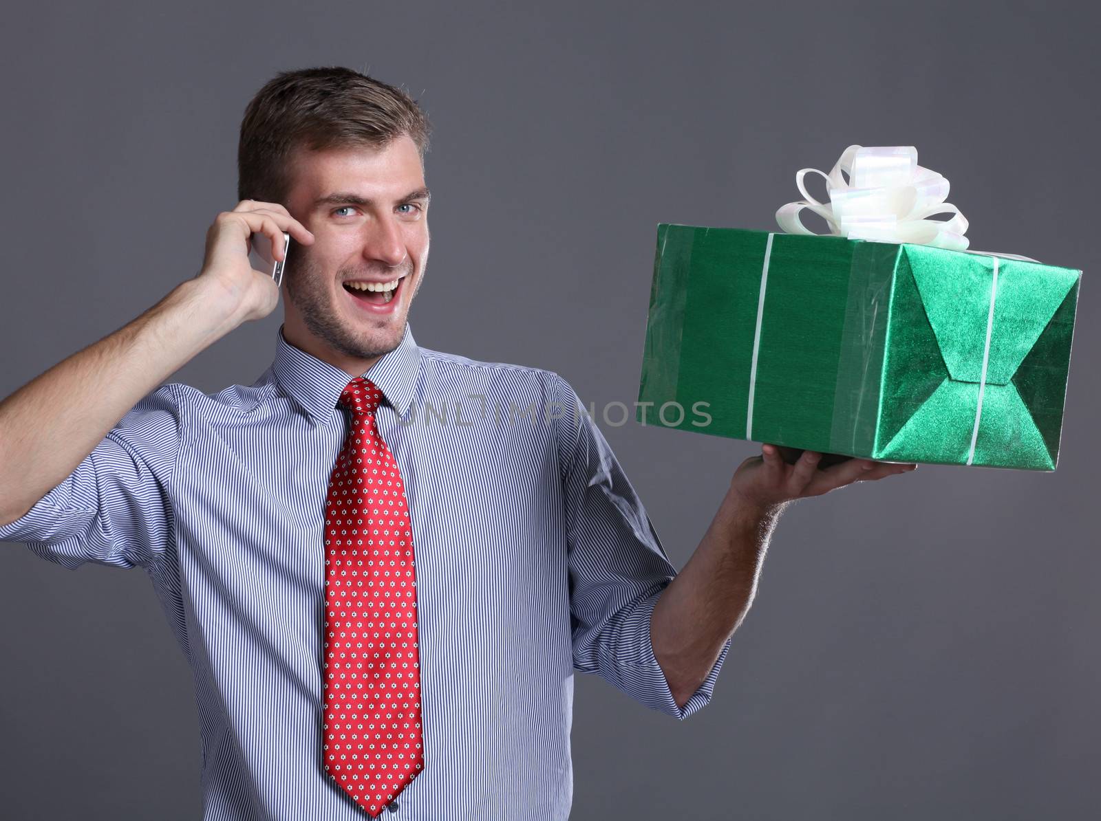 Portrait of young business man with gifts by andersonrise