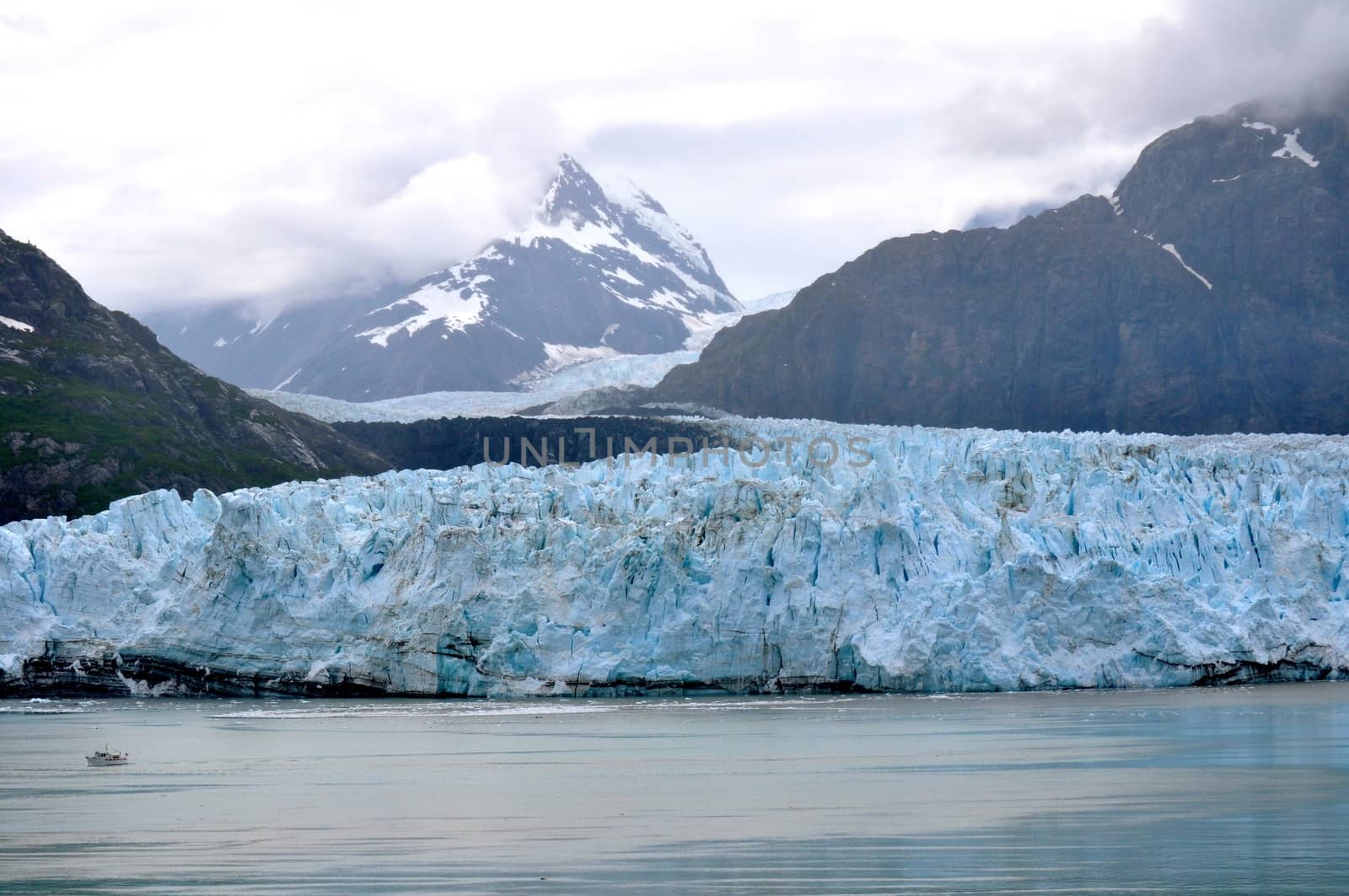  Alaskan Glacier overshadows boat on water