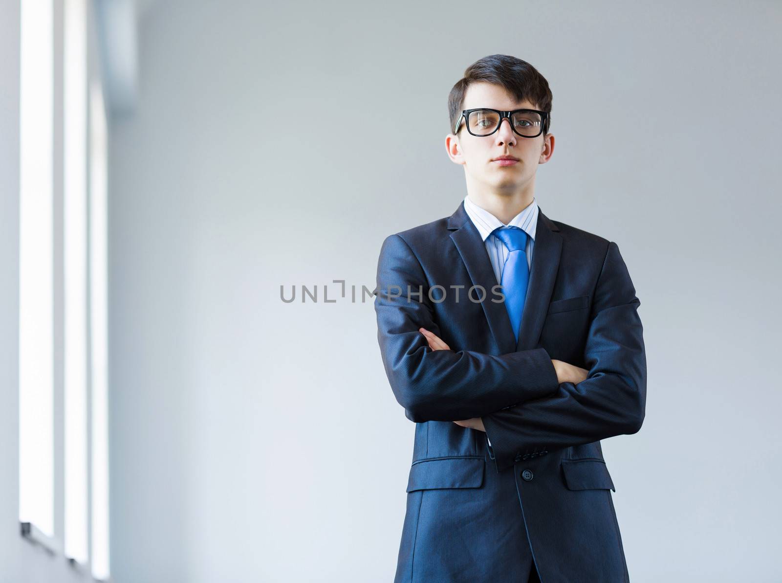 Image of handsome businessman in glasses with arms crossed on chest