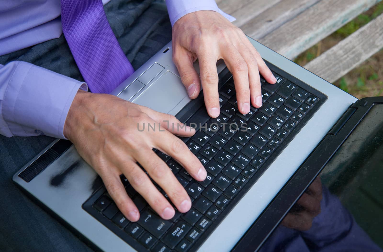 male hands typing on a laptop keyboard