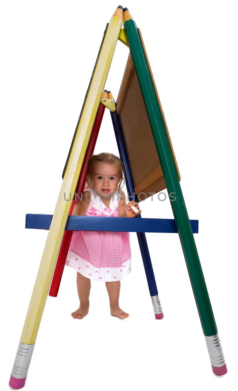 Cute little girl with bare feet playing on an A-frame signboard peering through underneath at the camera, isolated on white