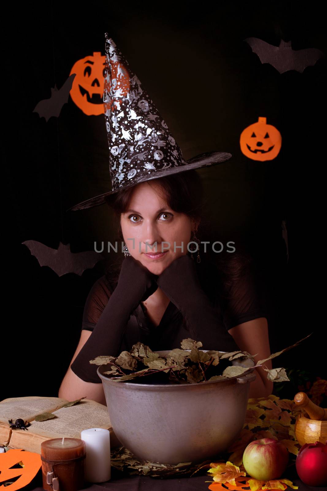 Nice witch practicing sorcery at Halloween night