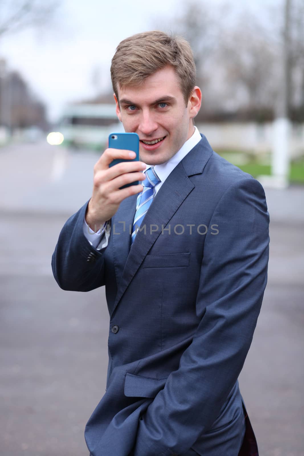 young attractive man calling by phone by andersonrise