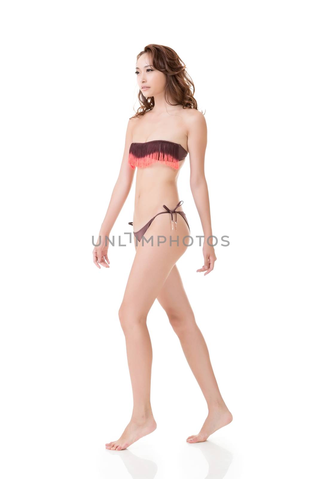 Summer bikini sexy asian young woman walking attractively. Full length portrait. Isolated on the white background.