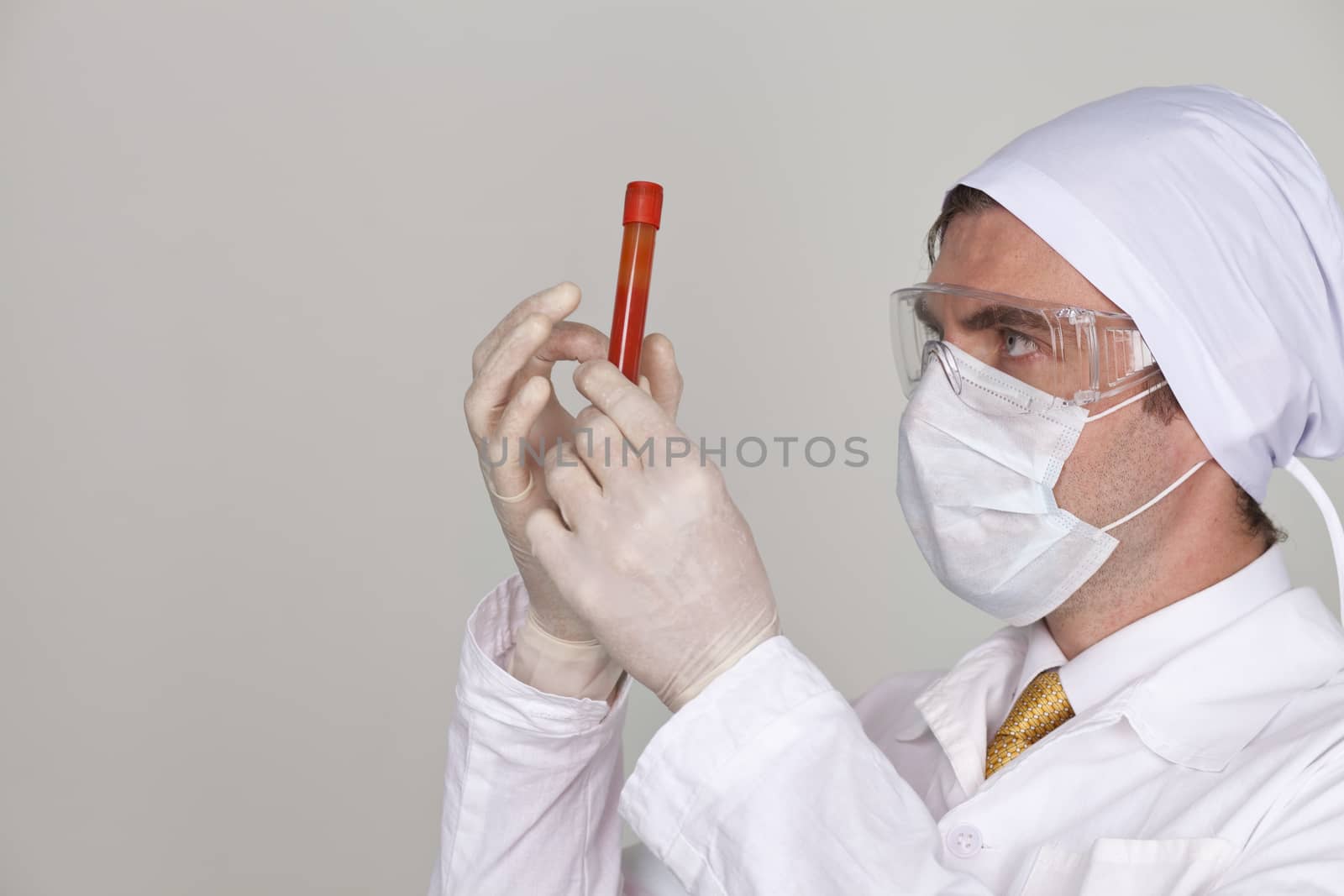 Doctor holding a beaker of blood by andersonrise