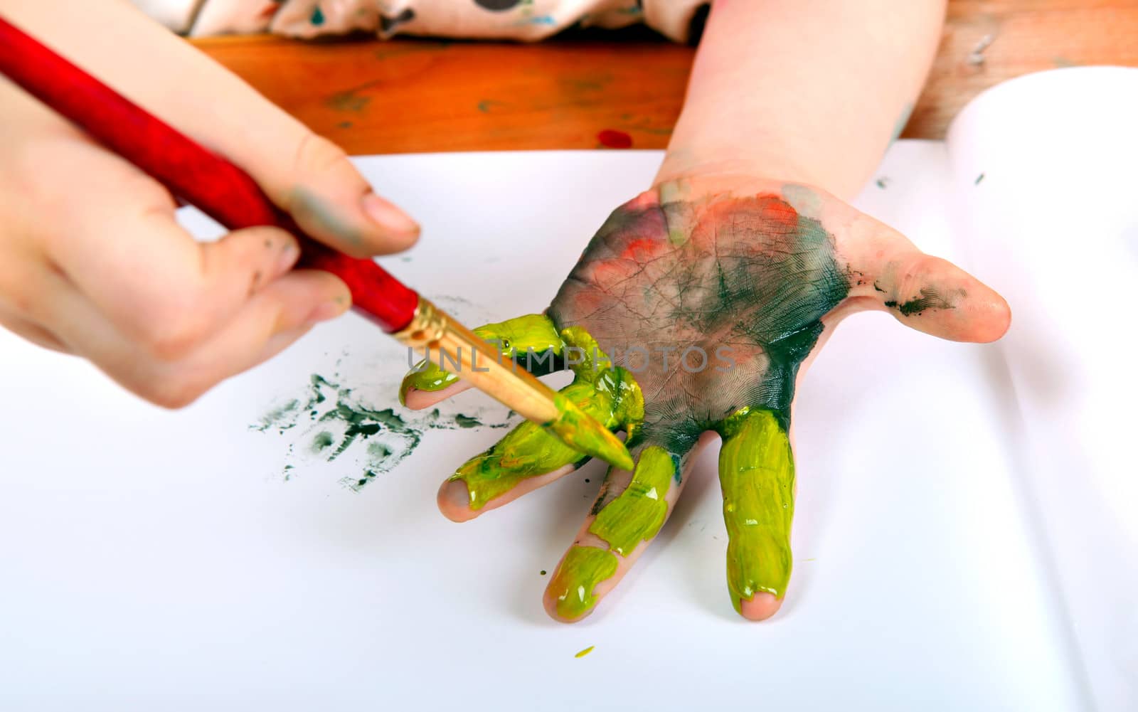 Little Girl Painting On Her Hand at the nursery class